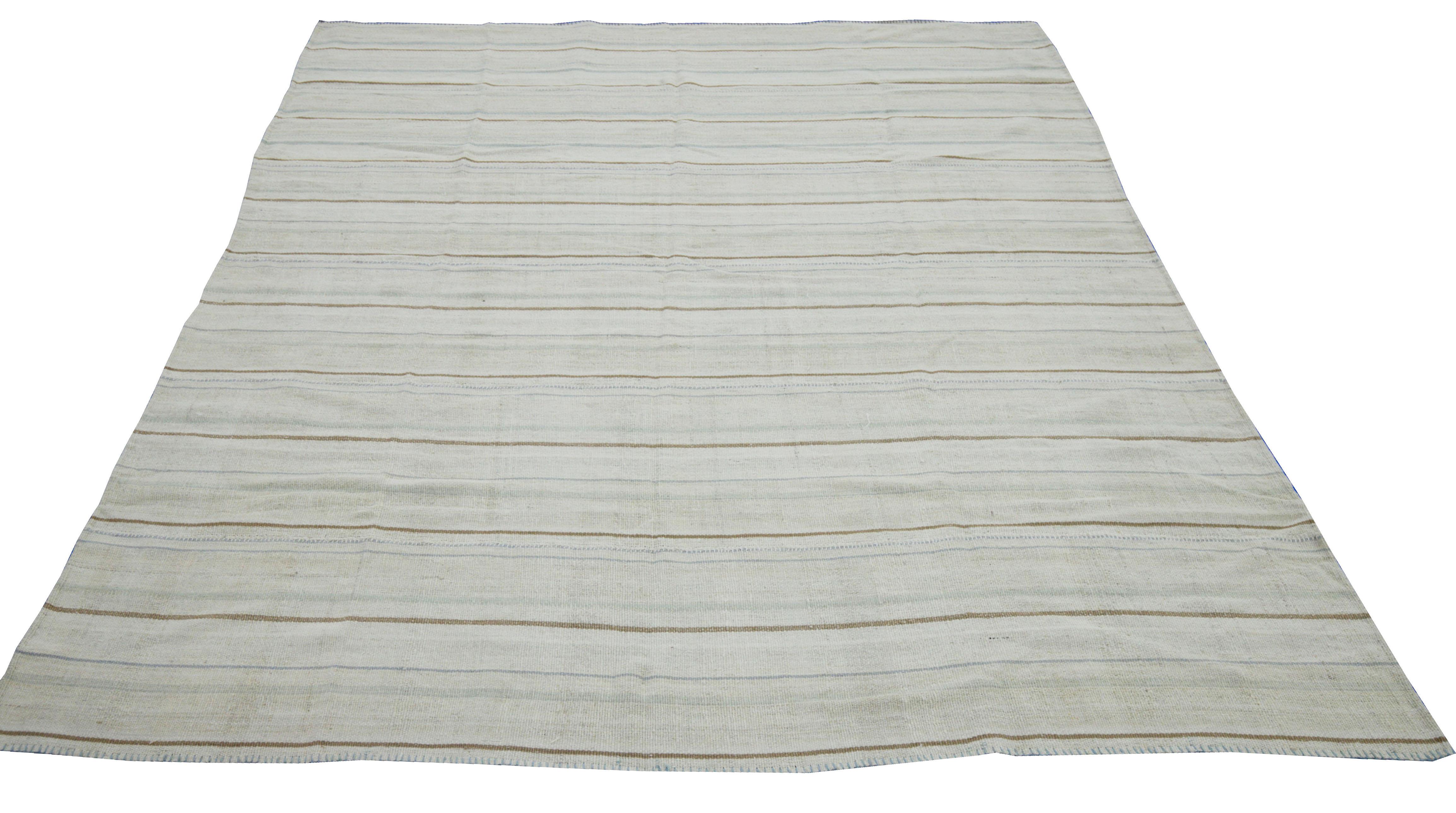  A new production Turkish rug handwoven from the finest sheep’s wool and colored with all-natural vegetable dyes that are safe for humans and pets. It’s a traditional Kilim flat-weave design featuring a lovely ivory field with gray, white and brown