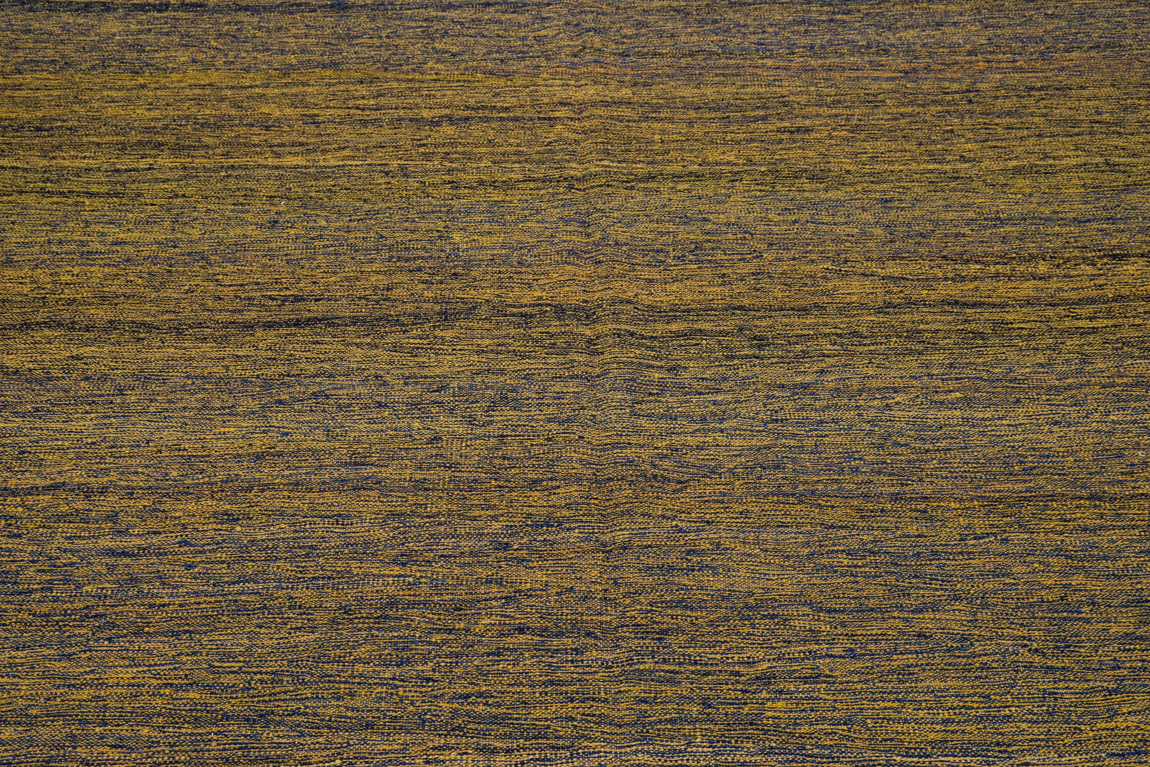 Ein moderner türkischer Kilim-Teppich, der in sorgfältiger Handarbeit gefertigt wurde, zeigt eine exquisite Anordnung von verschlungenen goldbraunen Streifen, die sich über die gesamte Oberfläche des Teppichs erstrecken.

Dieser Teppich misst 7'4