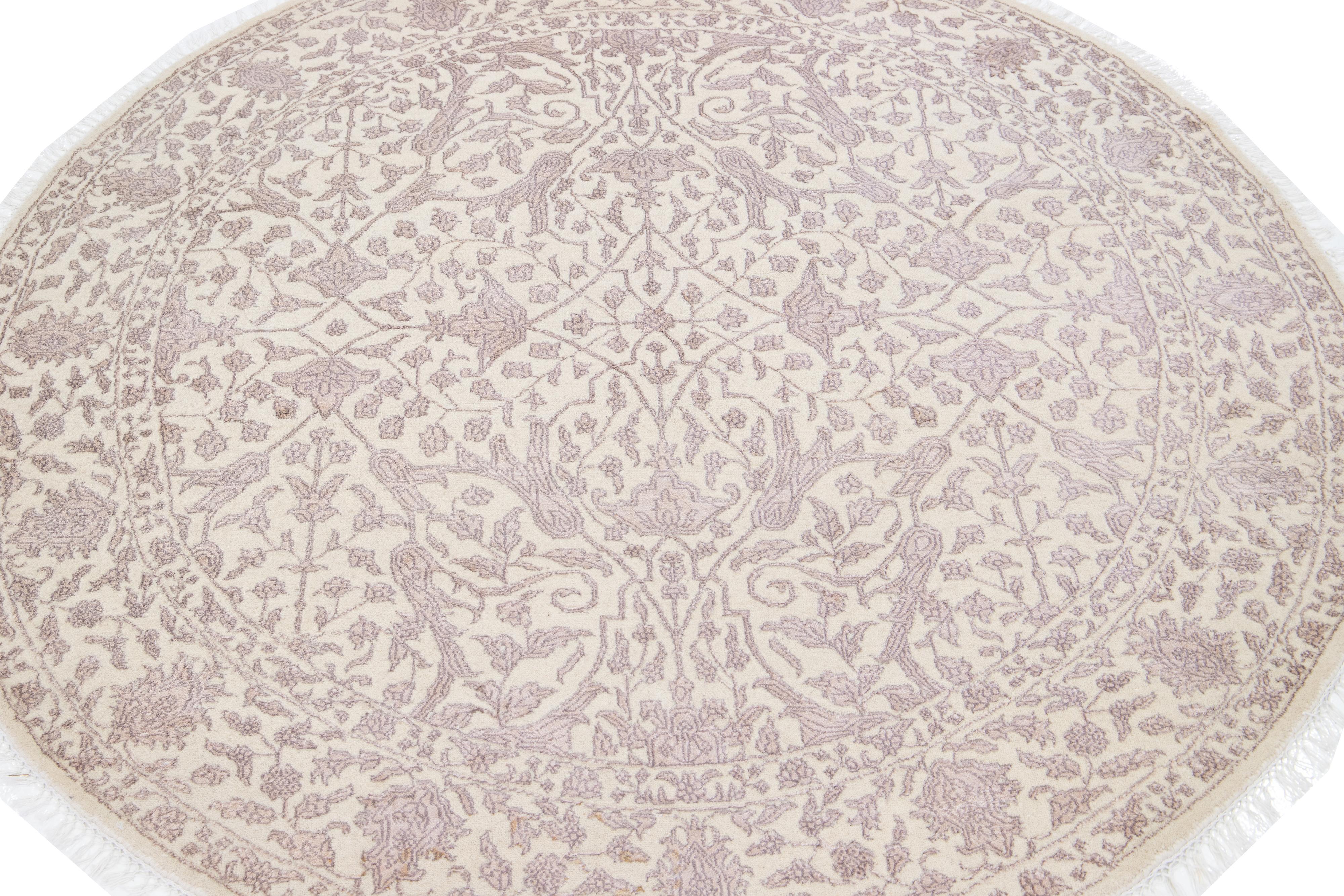 Beautiful Contemporary Indian hand-knotted wool and silk round rug with a beige field. This piece has rose accents in an all-over floral design with white fringes. 

This rug has a diameter of 6'1