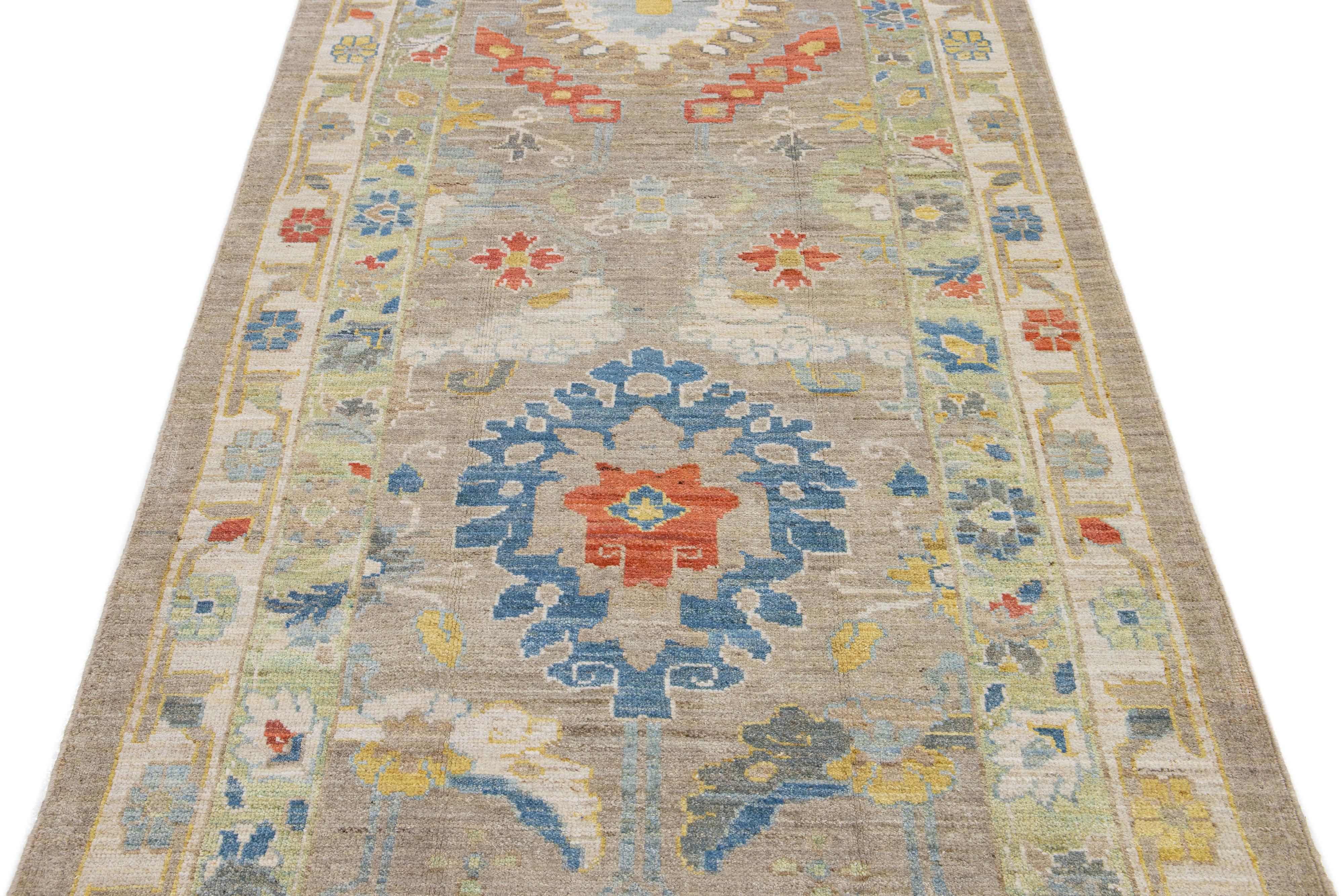 This contemporary take on the traditional Sultanabad style is showcased in an exquisite hand-knotted wool runner with a striking beige color. An intricately designed frame accentuates its all-over floral motif, adorned with multicolored accents that