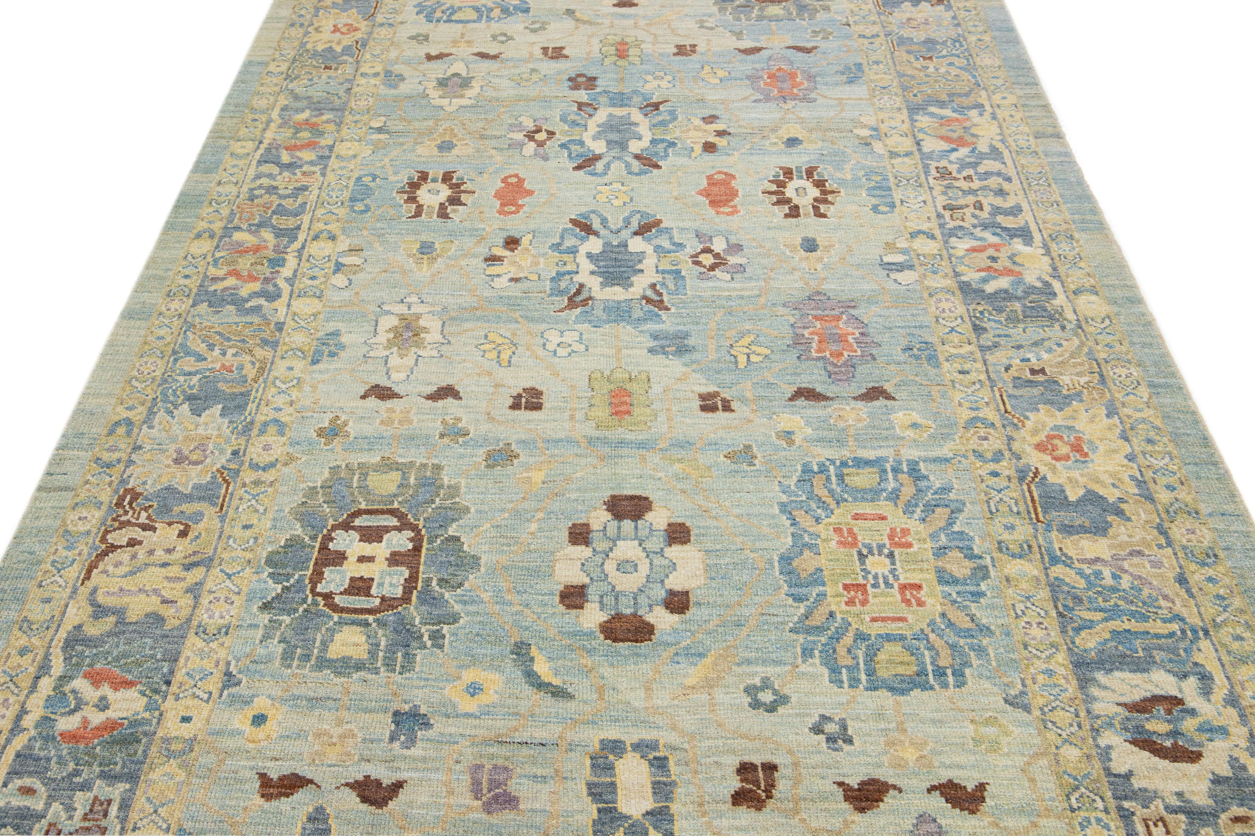 This stunning Sultanabad wool rug boasts contemporary beauty and craftsmanship, featuring a delightful blue color field accented by a navy blue framing with lovely multicolored highlights, which adds an elegant touch to the all-over floral