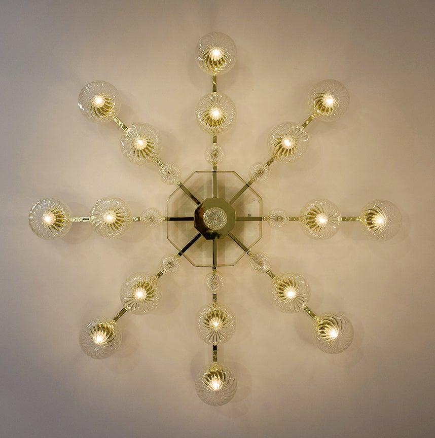 Italian modern flushmount with clear glass globes with twisted texture on 24-karat gold plated metal frame, designed by Fabio Bergomi for Fabio Ltd / Made in Italy
16 lights / E12 or E14 type / max 40W each
Measures: Diameter 51 inches, height 10.5