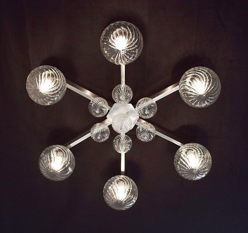 Italian modern flushmount with clear glass globes with twisted texture on satin nickel finish metal frame, designed by Fabio Bergomi for Fabio Ltd, made in Italy
6 lights / E12 or E14 type / max 40W each
Measures: Diameter 31 inches, height 9.5
