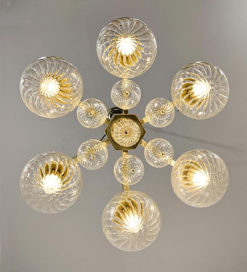Italian modern flushmount with clear glass globes with twisted texture on solid brass frame in lacquered polished finish, designed by Fabio Bergomi for Fabio Ltd / Made in Italy
6 lights / E12 or E14 type / max 40W each
Measures: Diameter 24 inches,