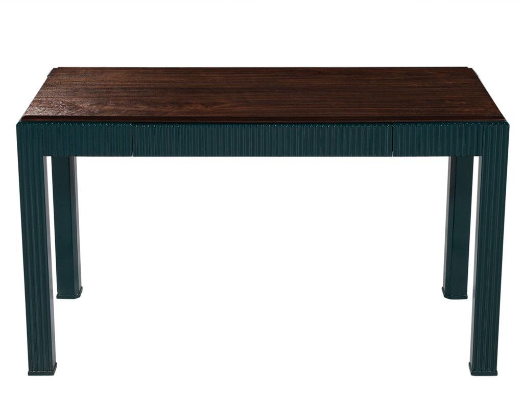 Ce bureau moderne en noyer cannelé est un magnifique meuble en bois de noyer, conçu avec un style moderne et un cadre cannelé fini dans une laque de couleur vert tortue avec une brillance semi-brillante. Le grand tiroir unique offre de nombreuses