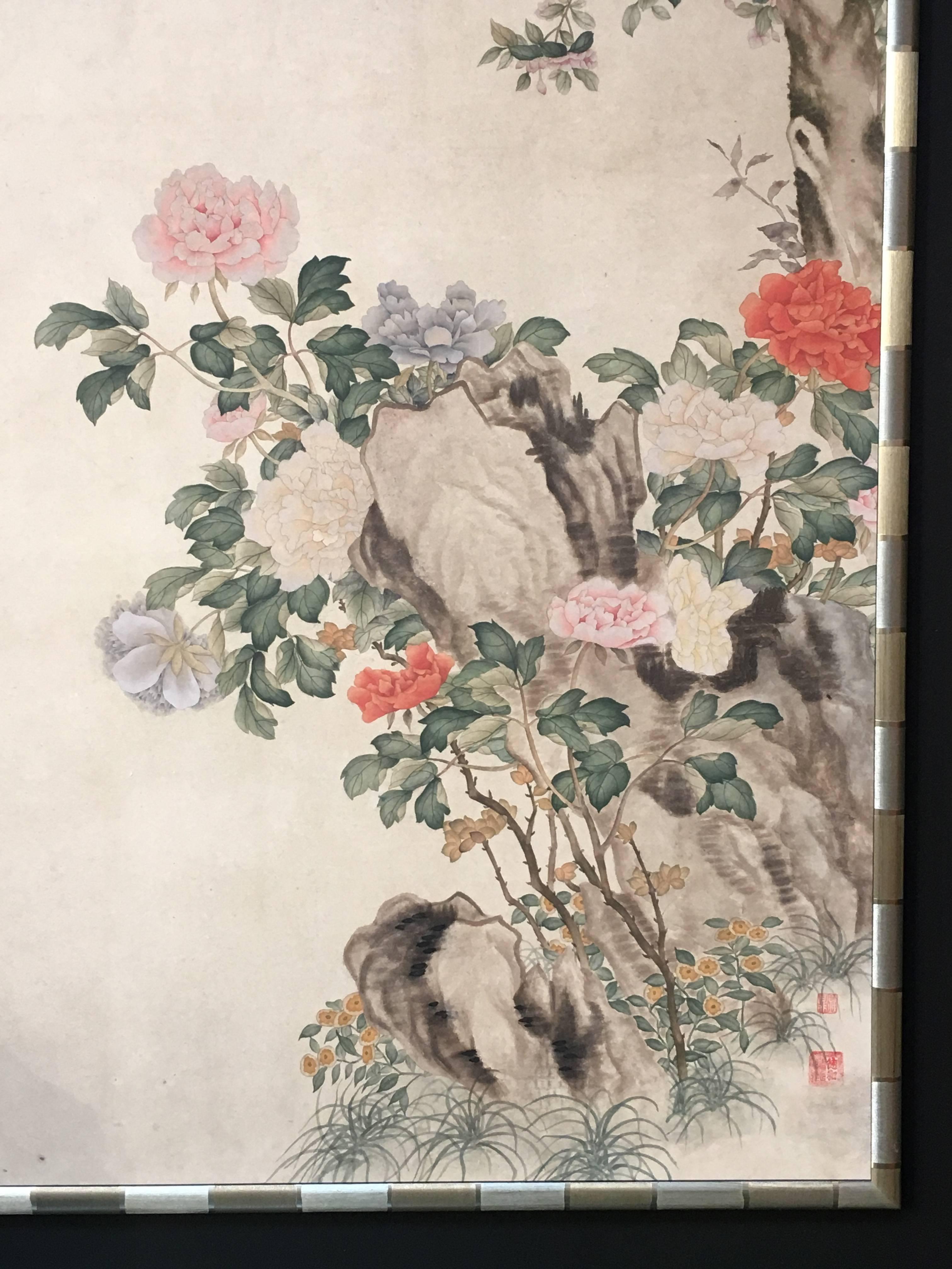 A gorgeous modern Chinese wallpaper style painting. Hand-painted watercolor on mulberry paper in a textured gold leafed bamboo pattern frame, with three seals of the artist. 
The painting depicting a floral scene, with blossoming peony on a rocky