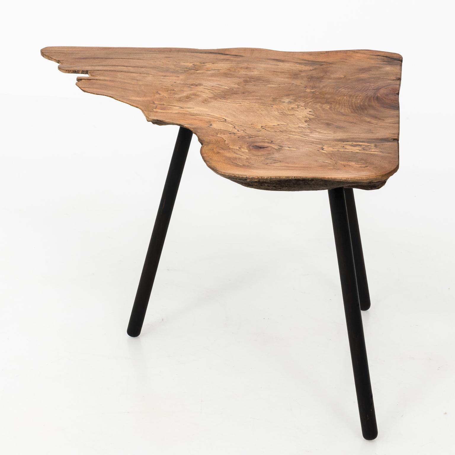 Modern freeform walnut coffee table with three black lacquered legs, circa 2000. Made in the United States.