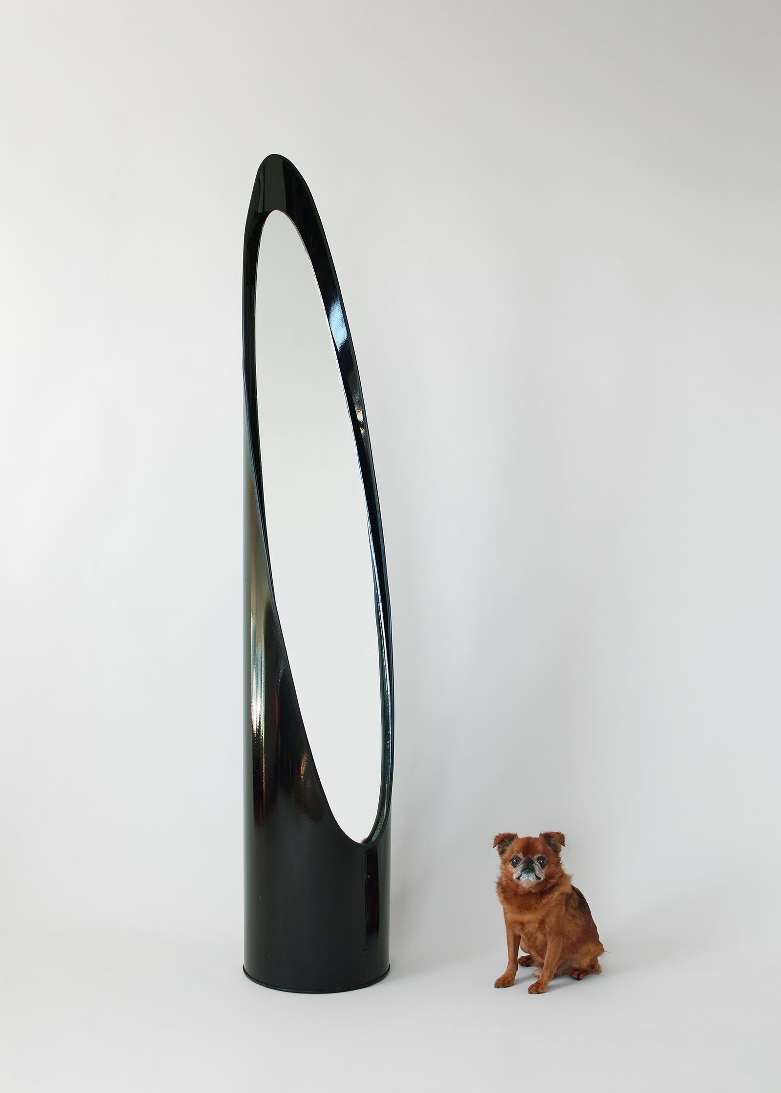 For your consideration is this freestanding full length lipstick mirror featuring a modern sliced tubular form with original inset glass mirror and black finish. It has a striking form and a nice compact 12