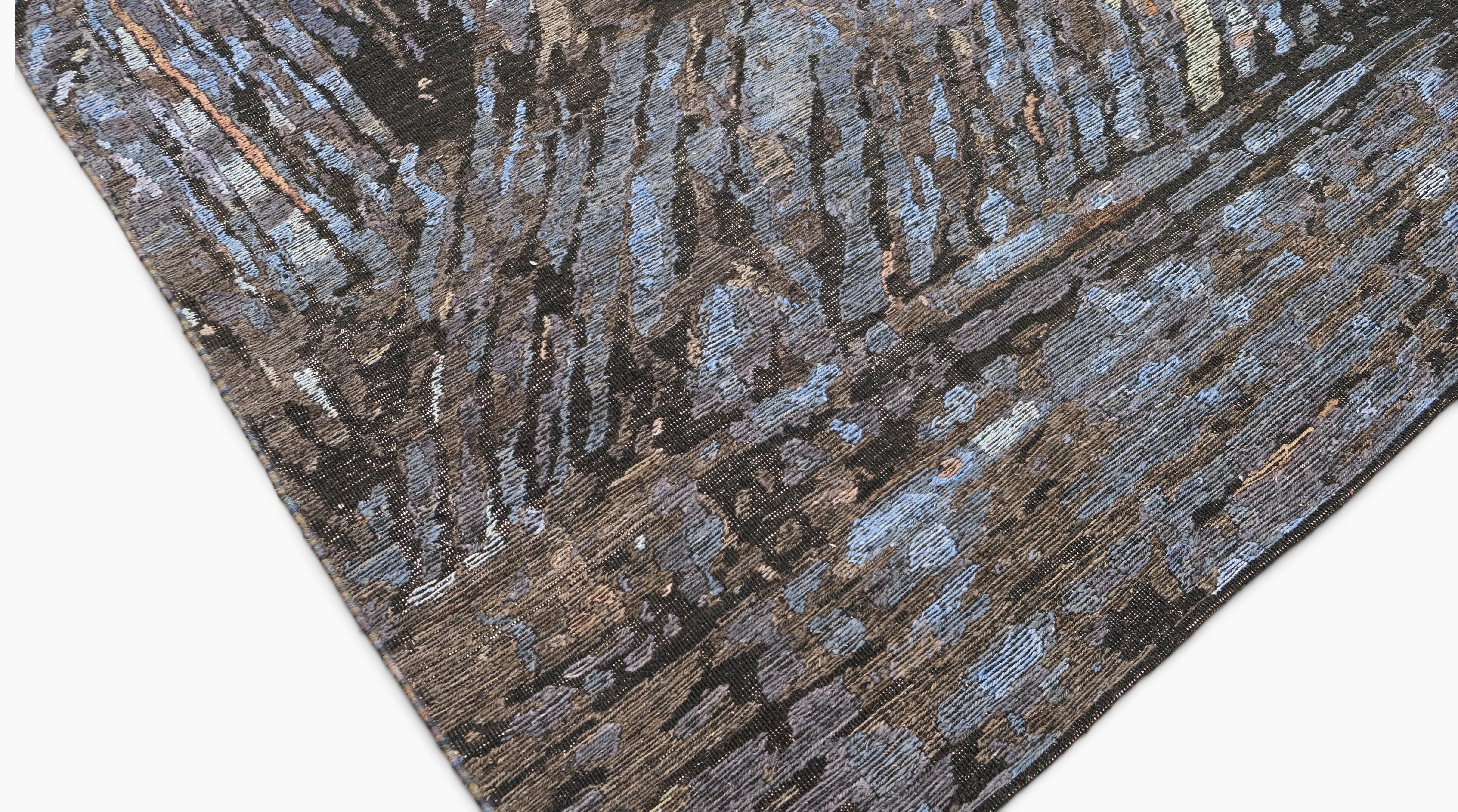 This hand-knotted wool and silk rug is a striking fusion of modern artistry and luxurious craftsmanship. Featuring an abstract pattern in shades of deep charcoal, and blue, the rug exudes a dynamic and expressive aesthetic, resembling fluid