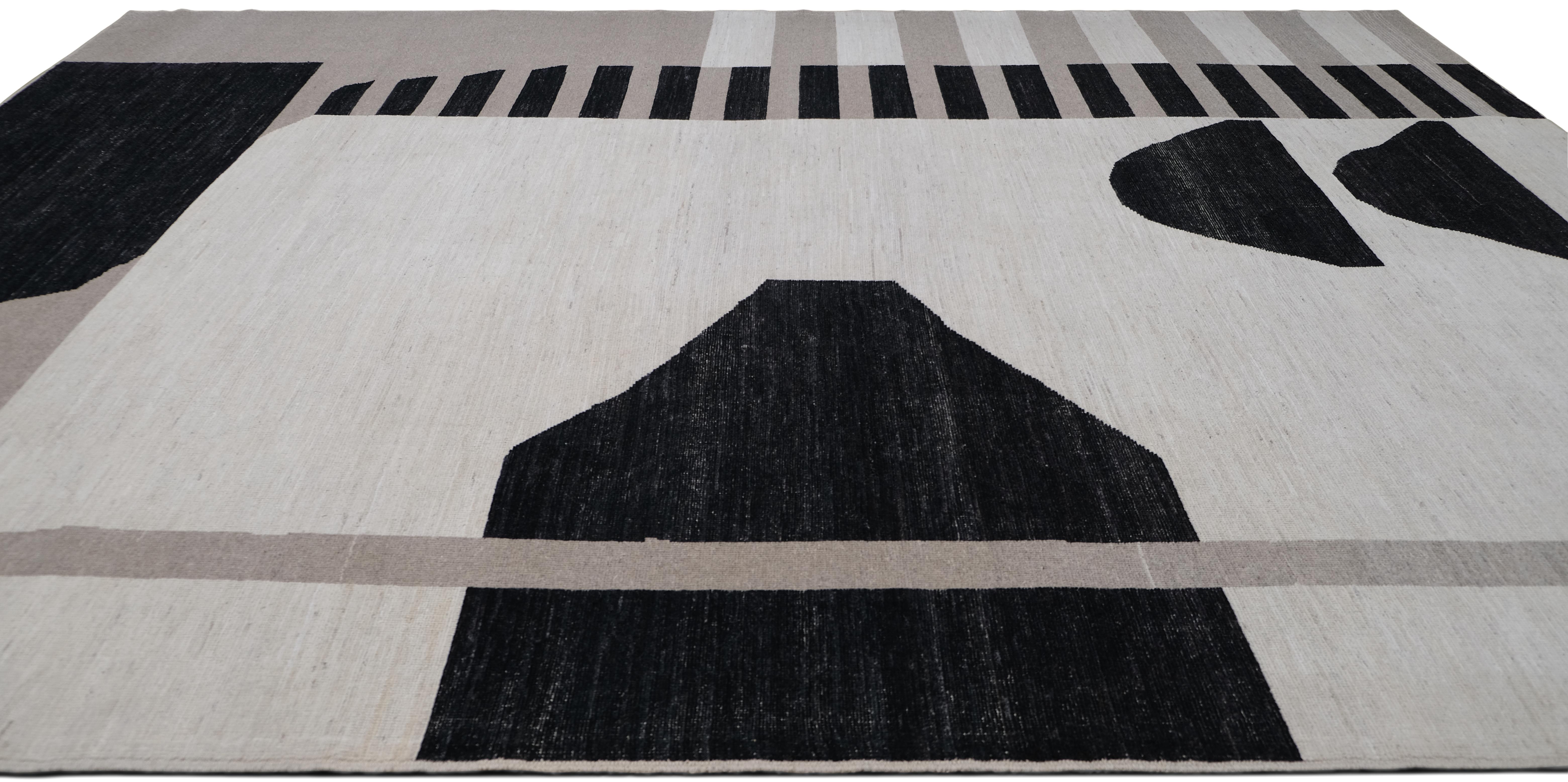 Esta alfombra de lana anudada a mano presenta un llamativo diseño abstracto moderno, con atrevidas formas geométricas en una paleta neutra de negro, beige y marfil. La composición asimétrica, que incluye rayas lineales, formas angulares y siluetas
