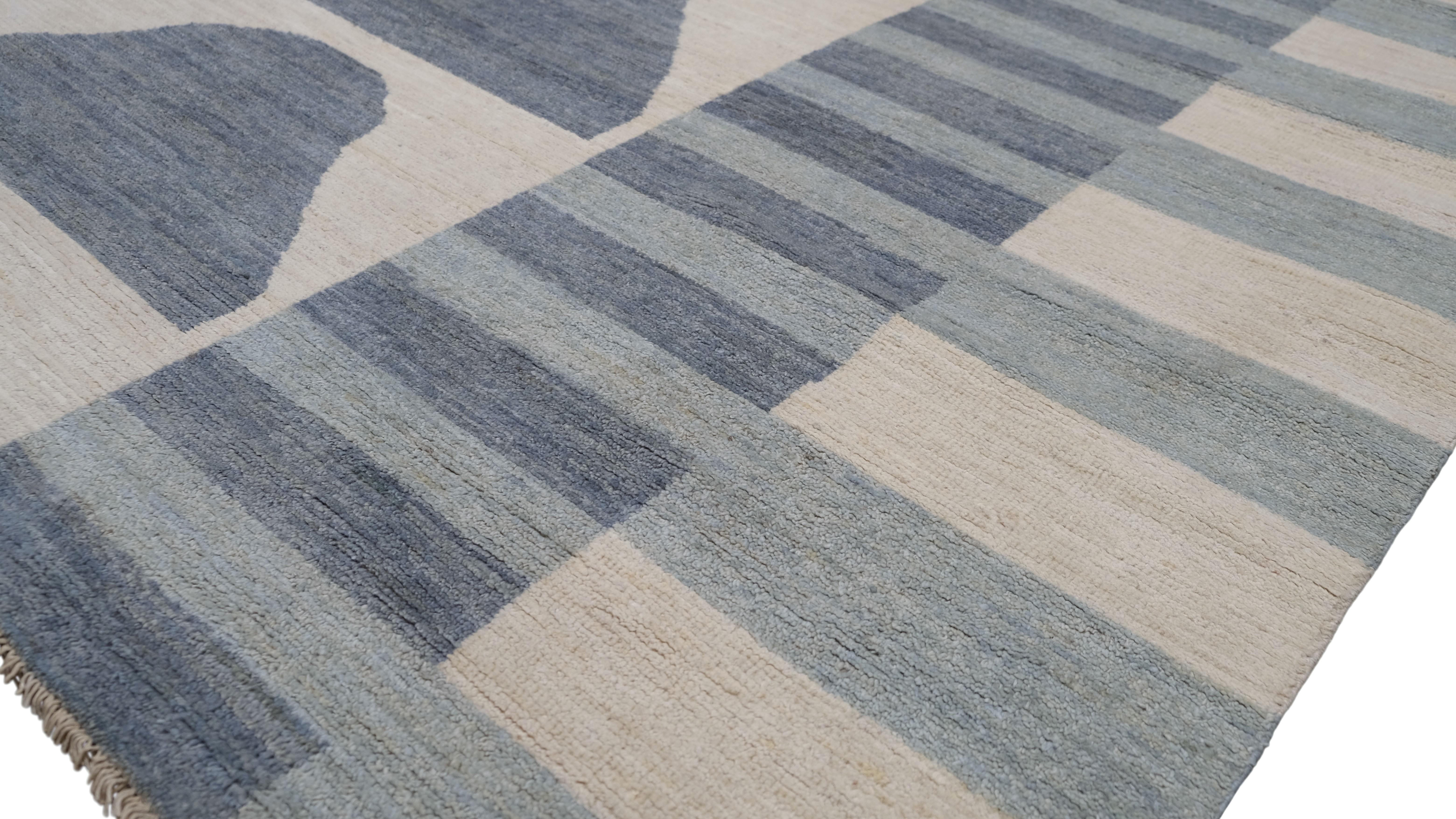 Elevate your interior with this stunning hand-knotted wool rug, featuring a sophisticated blend of blues and Ivory tones arranged in a striking geometric and abstract pattern. This rug's clean lines and artistic design make it a perfect fit for
