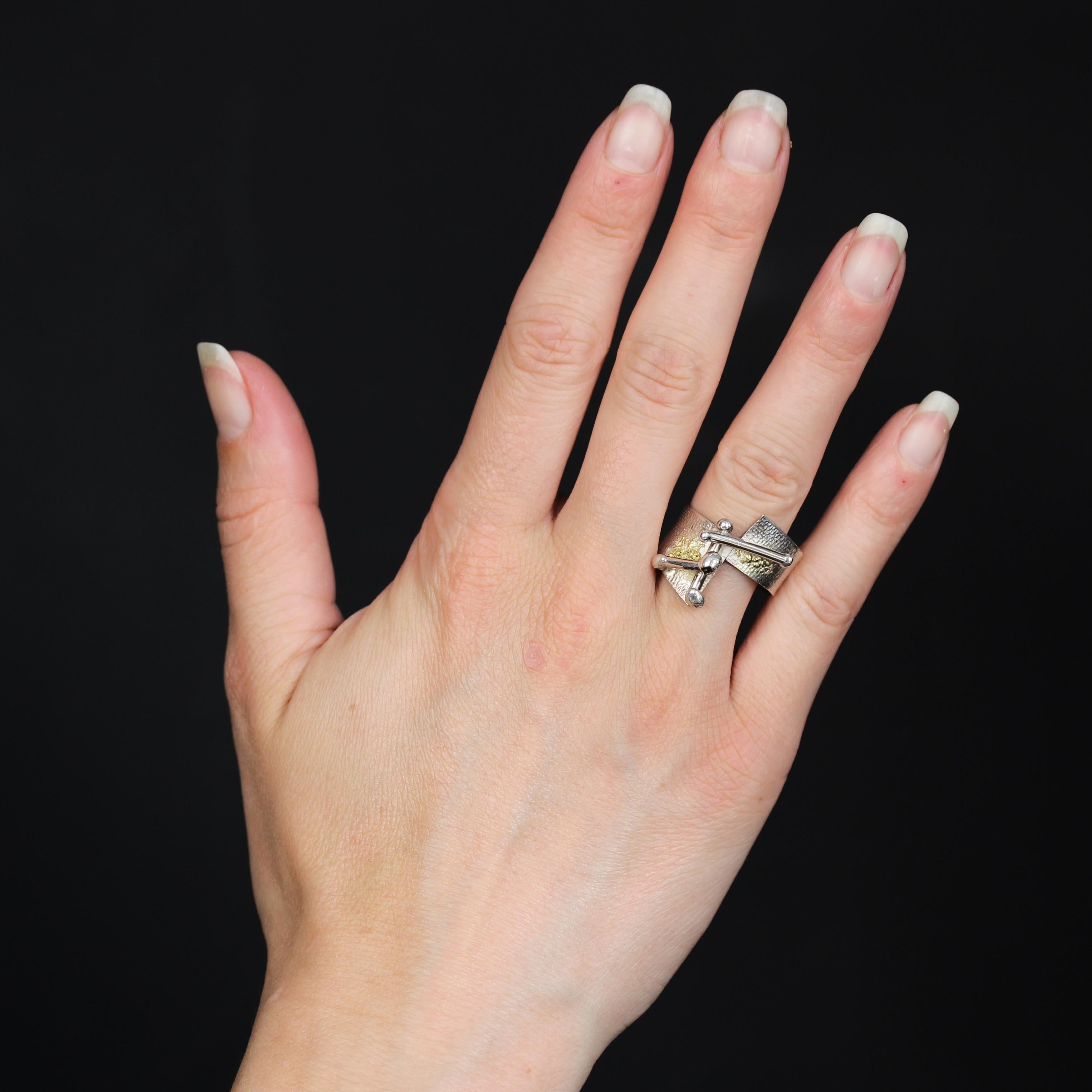 Anello in argento con marchio Minerva.
Un anello a fascia con un nastro piatto martellato che si incontra in modo asimmetrico nella parte superiore. È ornato da 3 barre con punta di perla applicate in modo asimmetrico e incastonate in un motivo di