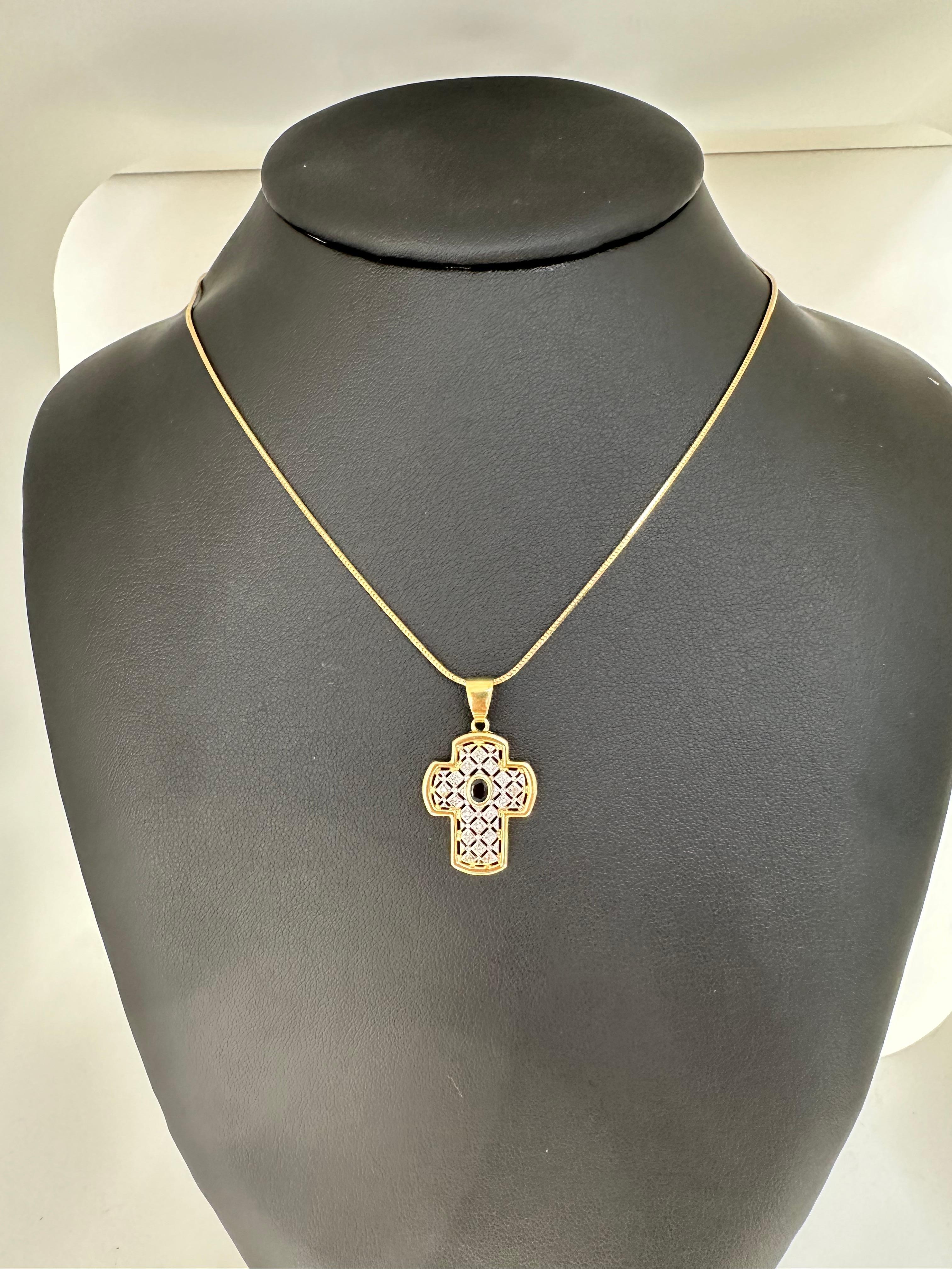 Questo ciondolo a croce francese moderno è un pezzo chic e raffinato che unisce il design contemporaneo all'eleganza classica. Realizzata in oro giallo e bianco 18 carati, presenta una splendida disposizione di gemme e una lavorazione a giorno che