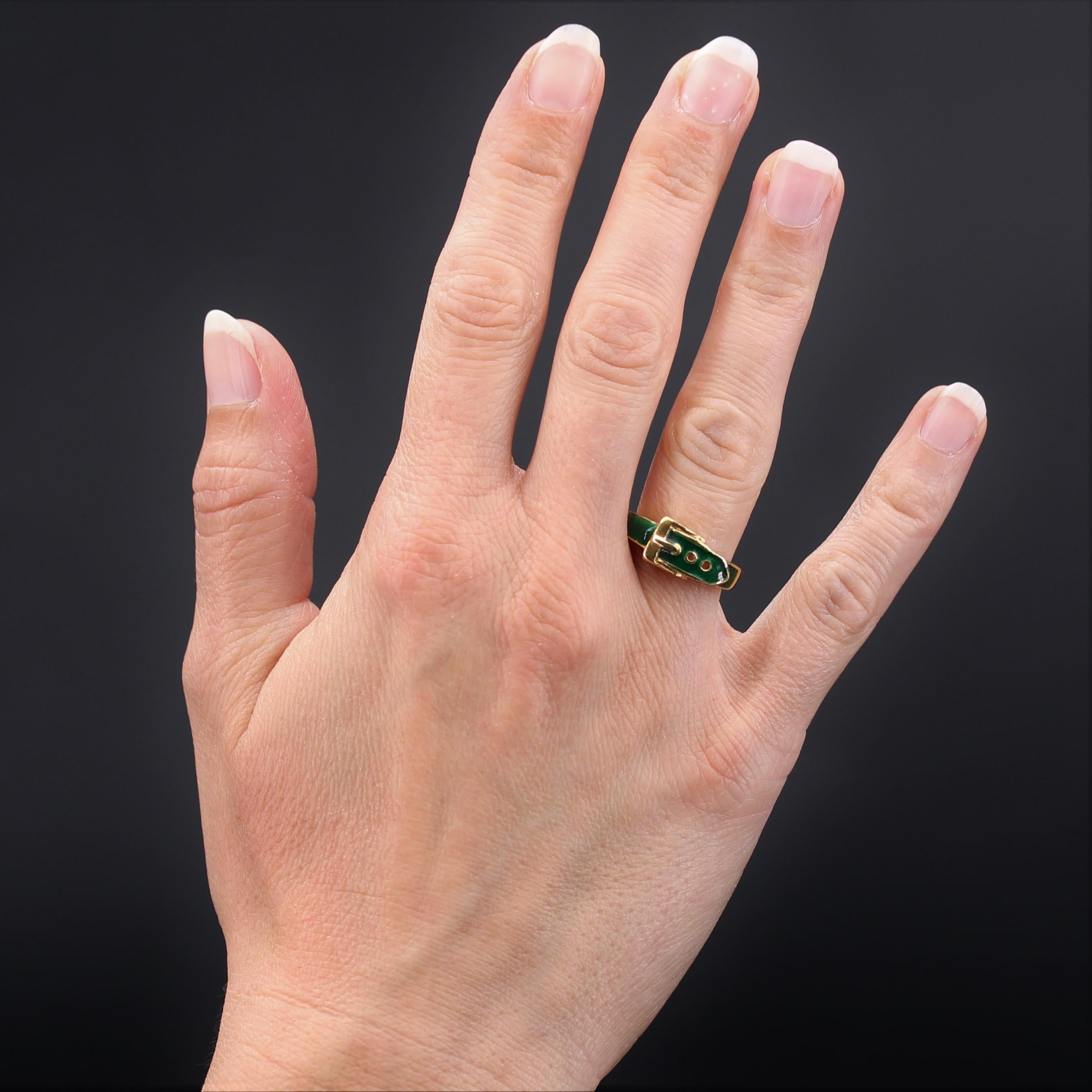Ring in 18 karat yellow gold, eagle head hallmark. 
This ring is in the shape of a green enamel buckled belt. 
Height: 7.5 mm approximately, thickness: 4.3 mm approximately, width of the ring at the base: 2.5 mm approximately.
Total weight of the