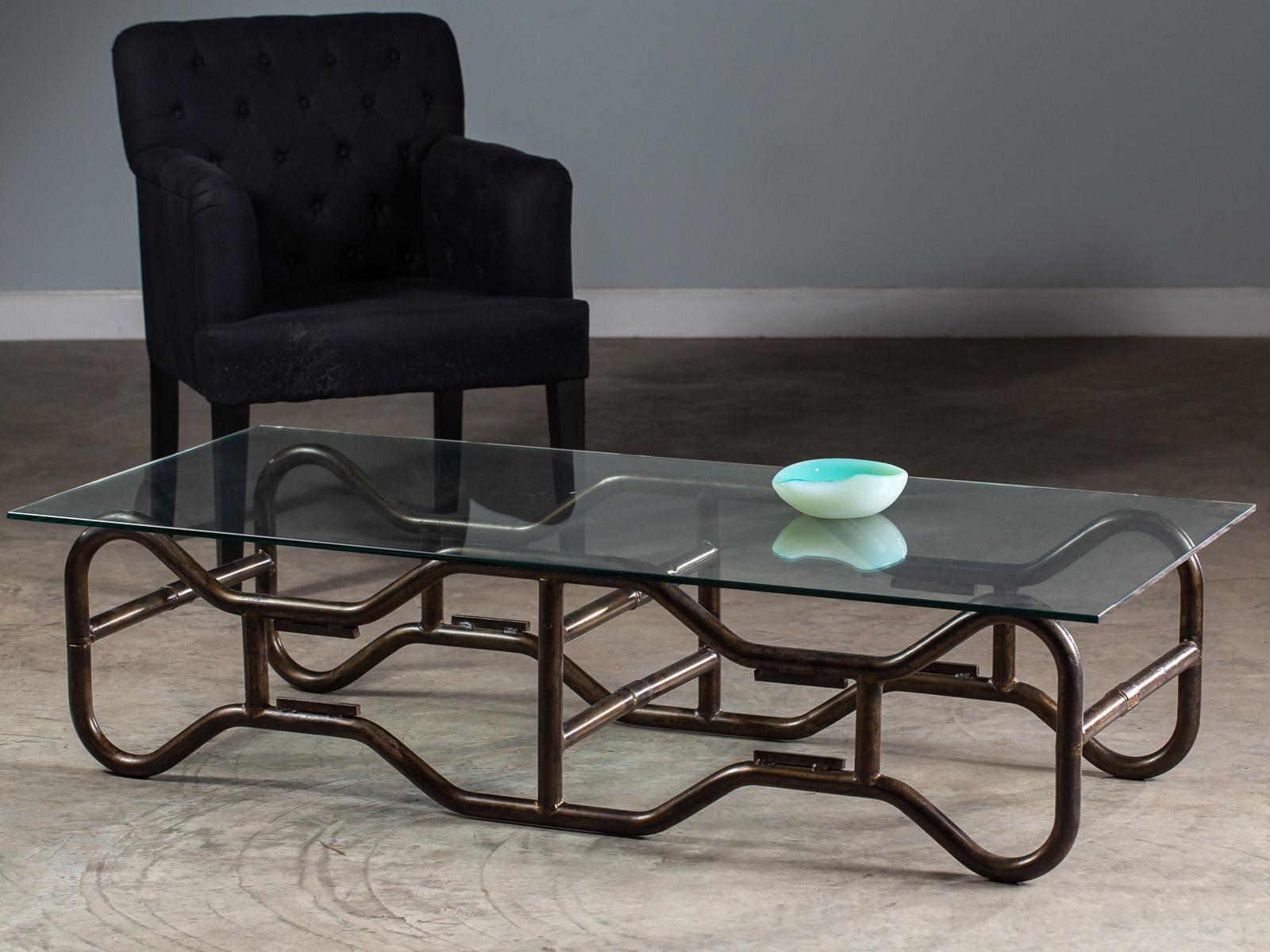 A modern French industrial tubular steel frame coffee table from France circa 1970 with a glass top. The striking profile of this table base showcases its modernist origin both in the material employed as well as the open framework design. By using