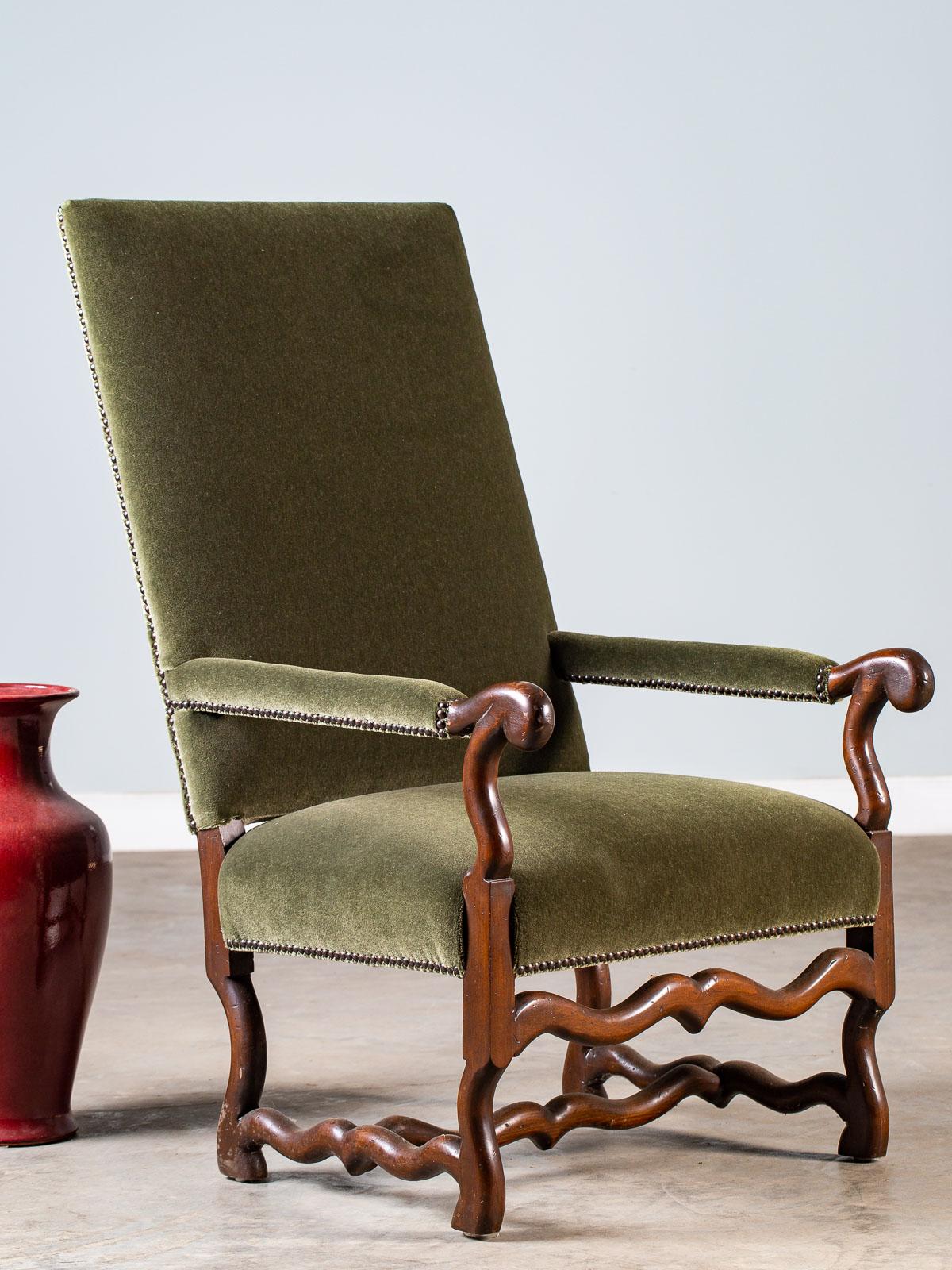 A modern French copy of a Louis XIII style mouton leg armchair with distinctive features covered in a green mohair fabric. What sets this chair apart is the slant of the back and the fully upholstered arms which gives this chair its amazingly