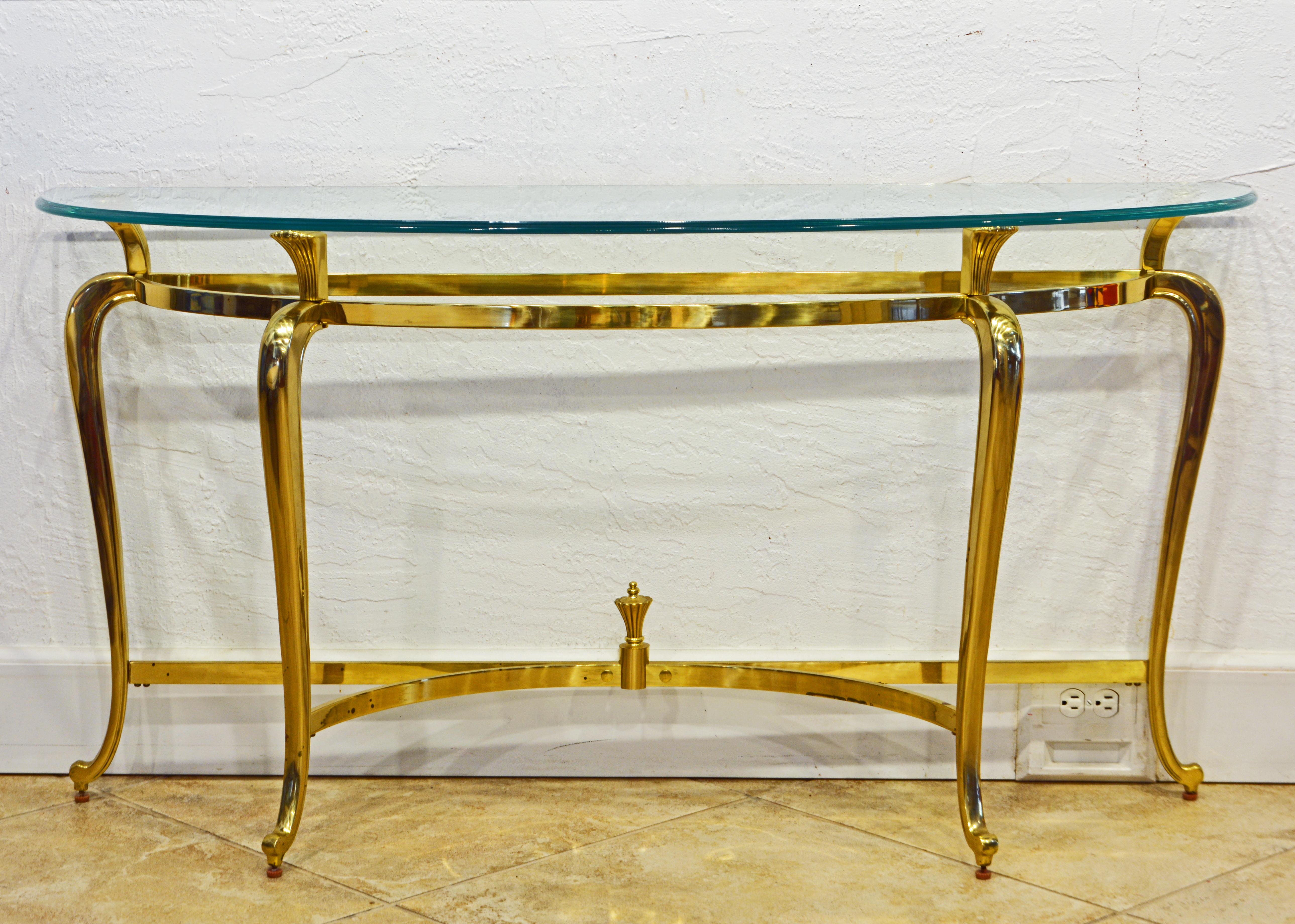 What is so striking about this solid brass demi lune console table is the fusion of traditional cabriole legs and a perfectly modern design. The table is more slender (elongated) than ordinary demi lune tables providing a combination of great width