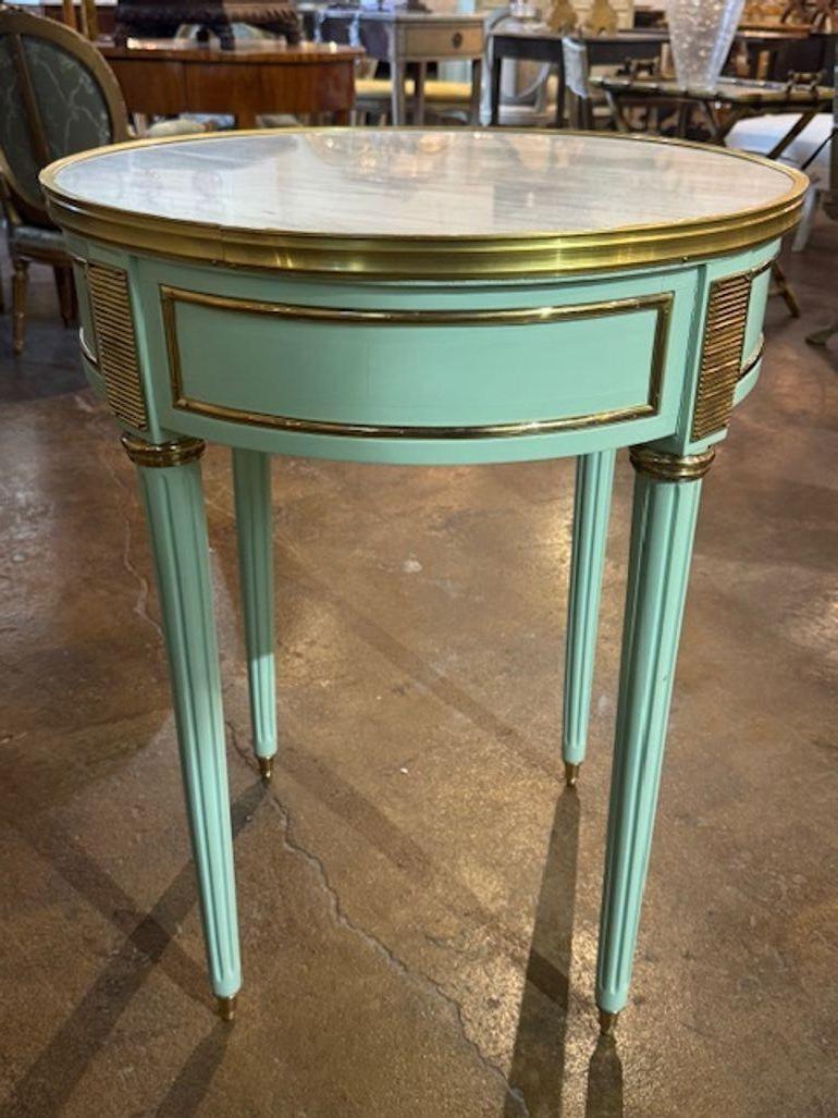 La moderna mesa auxiliar francesa estilo Luis XVI Jansen pintada en verde pálido, con tapa de mármol incrustada, es un mueble lujoso y elegante para cualquier hogar. Bonitos detalles de latón también. Esta pieza añade un toque de refinamiento