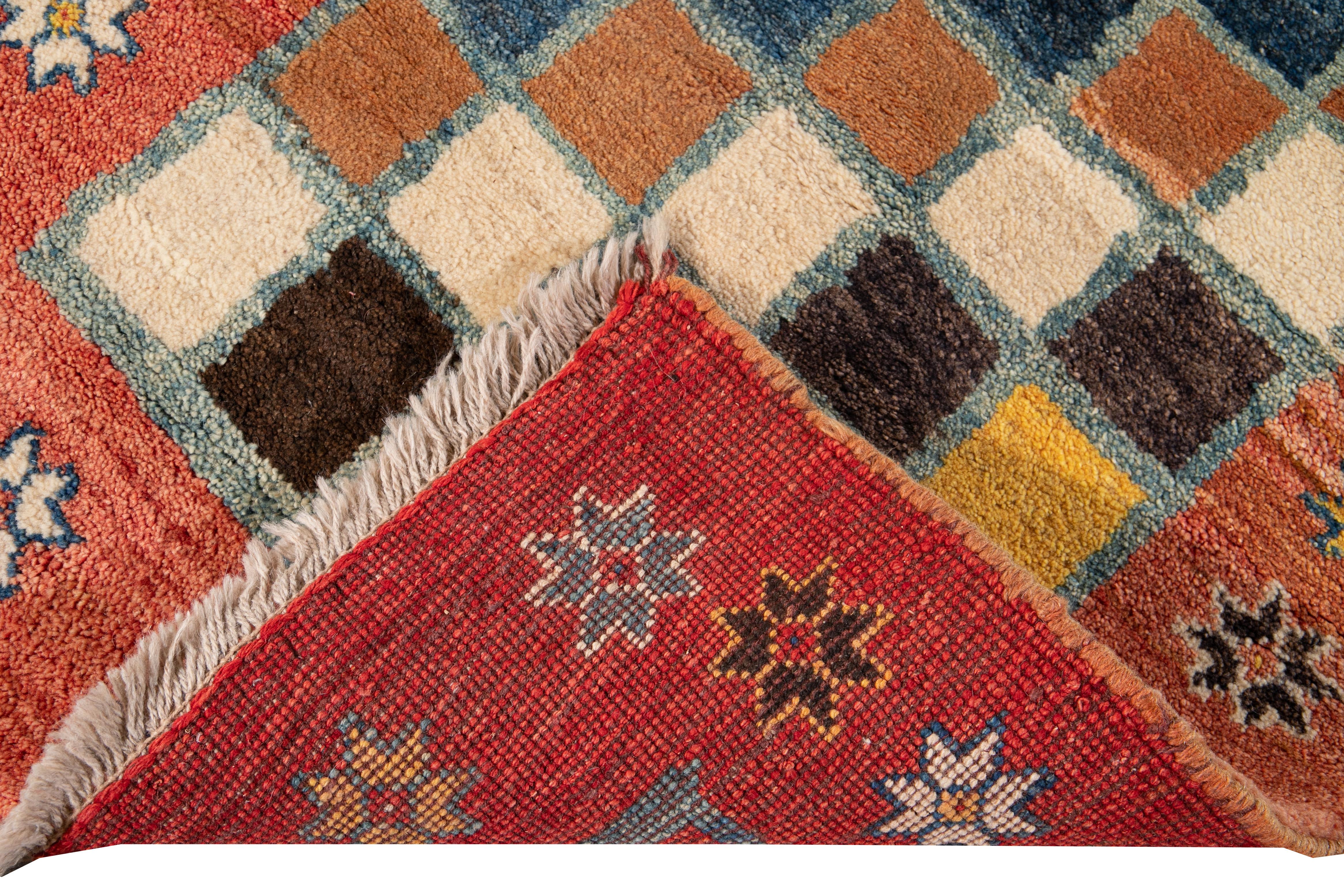 Beautiful modern Persian Gabbeh hand knotted wool runner with a multi-color checked field. This Gabbeh runner has an orange gorgeous geometric floral design.

This rug measures: 2'9