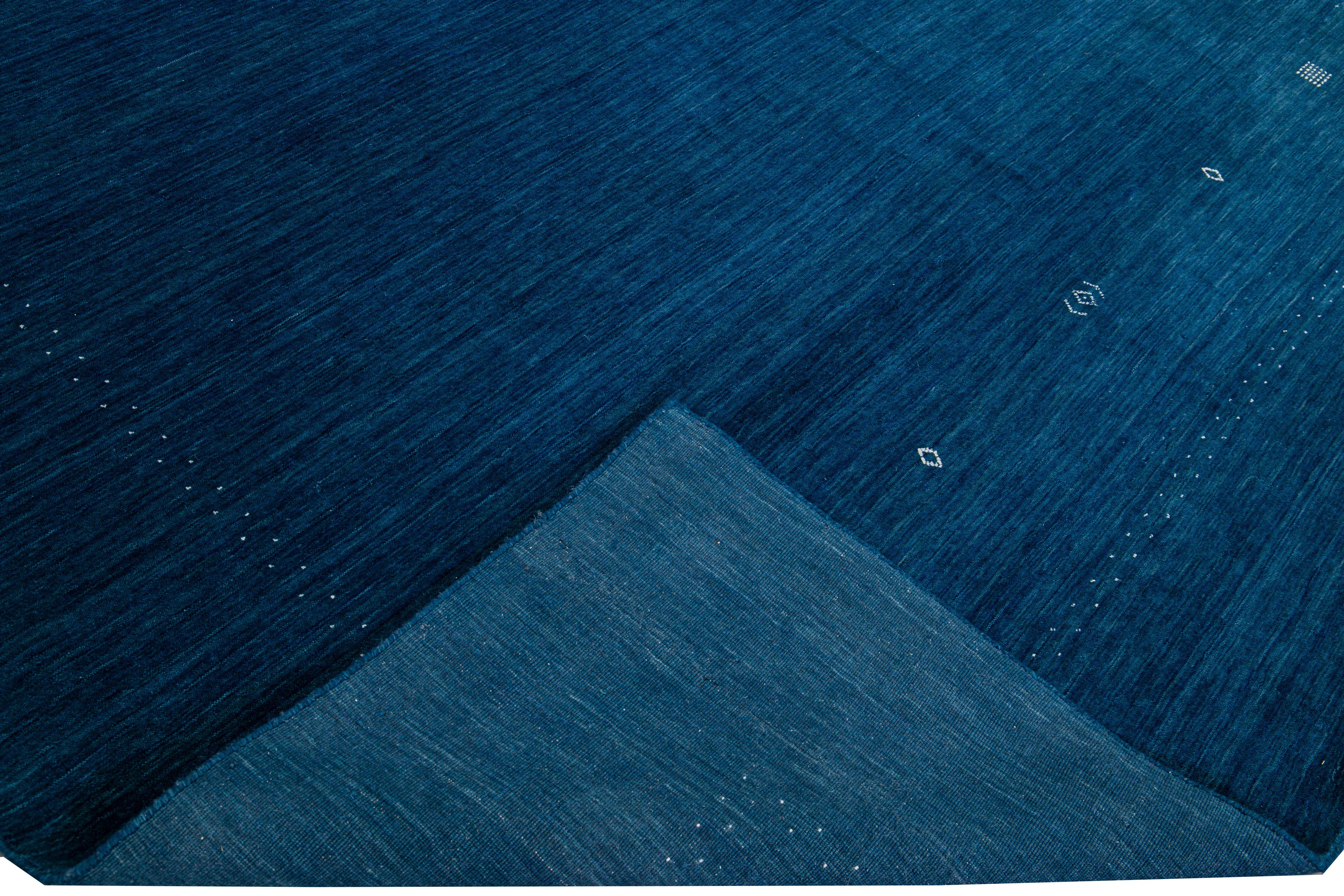 Schöner moderner Gabbeh-Stil Hand-Loom Wollteppich mit marineblauem Feld. Dieser Teppich im Gabbeh-Stil hat elfenbeinfarbene Akzente in einem herrlichen geometrischen Minimal-Design.

Dieser Teppich misst: 10'1