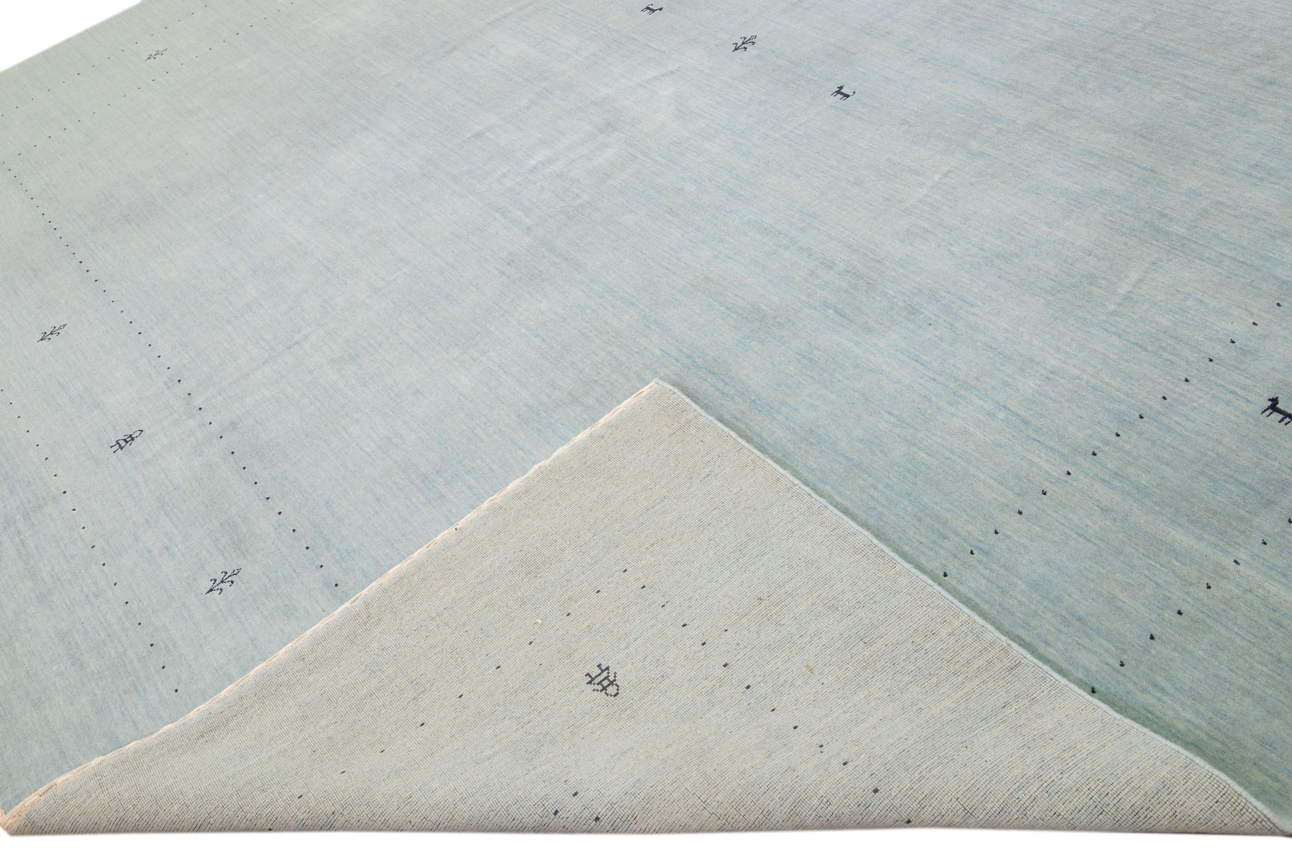 Beautiful modern Gabbeh style hand-Loom wool rug with a Light Blue field. This Gabbeh-style rug has black accents in a gorgeous all-over geometric minimal design.

This rug measures: 12'2