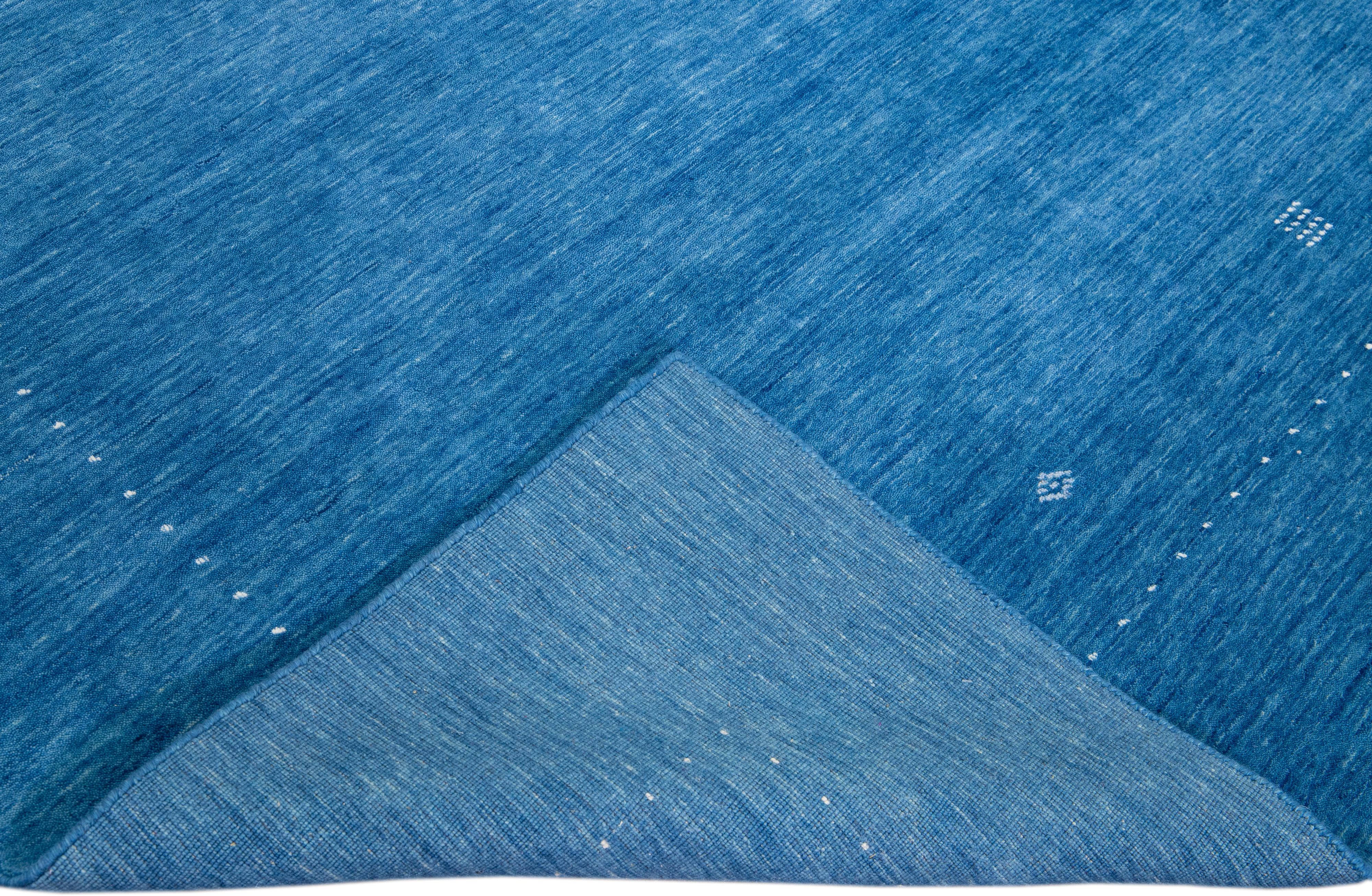 Schöner moderner Gabbeh-Stil Hand-Loom Wollteppich mit dem azurblauen unifarbenen Feld. Dieser Teppich im Gabbeh-Stil hat weiße Akzente in einem herrlichen geometrischen Minimal-Design.

Dieser Teppich misst: 9'2