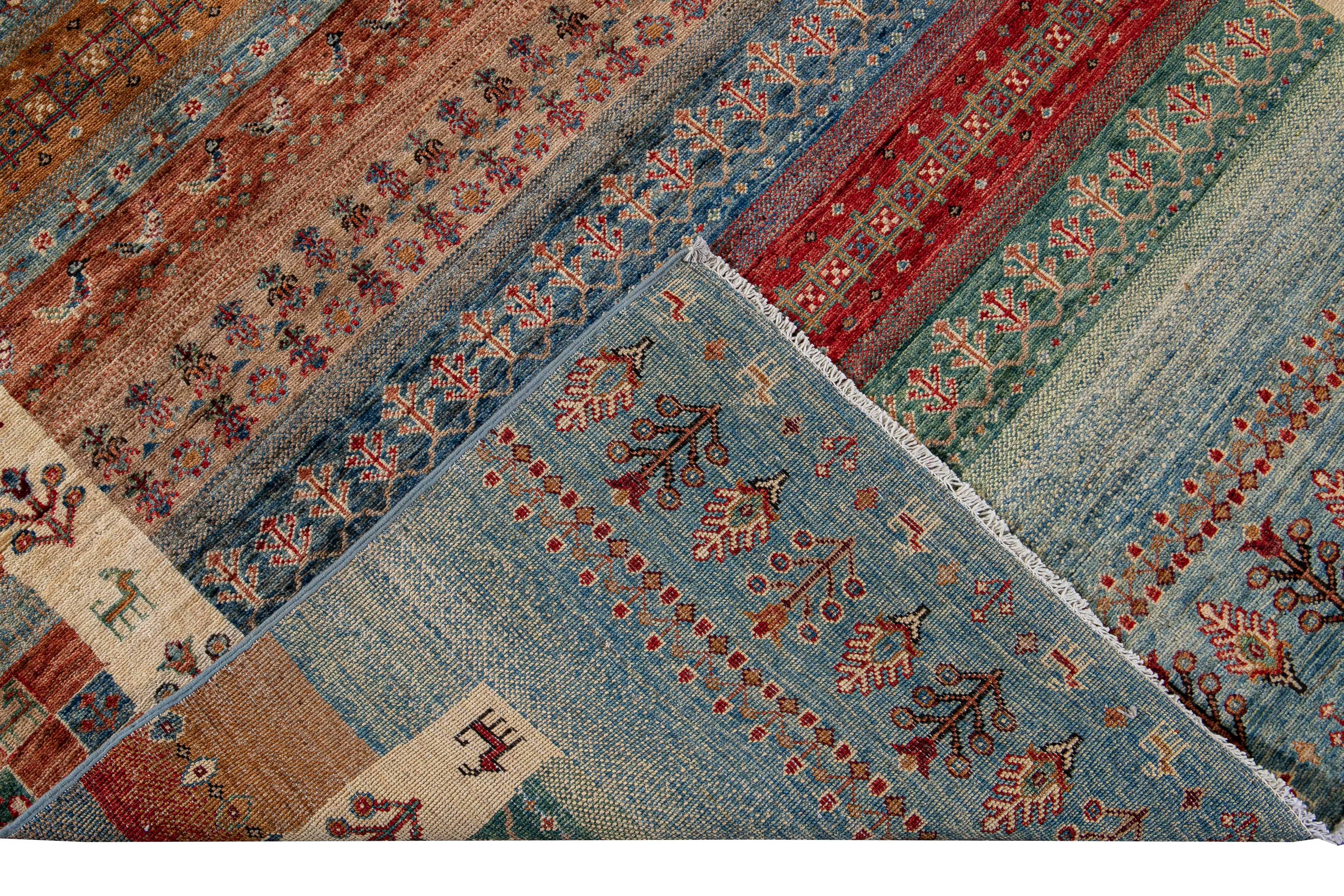 Schöner moderner, handgeknüpfter Wollteppich im Gabbeh-Stil mit blauem, orangefarbenem, grünem und rotem Feld. Dieser Teppich im Gabbeh-Stil hat ein wunderschönes geometrisches Muster, das überall zu sehen ist.

Dieser Teppich misst: 5' 1