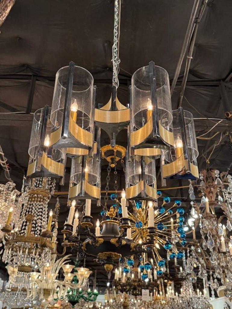Le lustre moderne Gaetano Sciolari en chrome et laiton est un appareil d'éclairage élégant conçu par le célèbre designer italien Gaetano Sciolari. Ce lustre présente une combinaison élégante de chrome et de laiton, ce qui lui confère un aspect