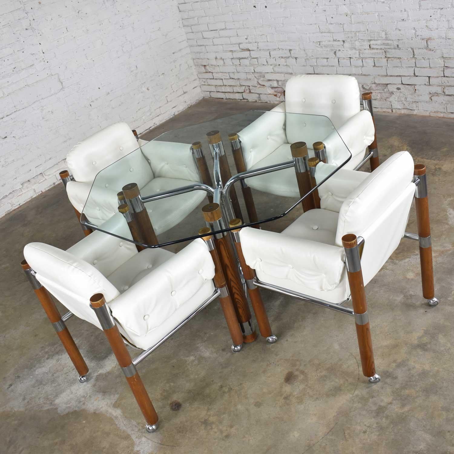 Awesome modern midcentury Campaign style game table or dining table in oak and chrome with glass top and four white vinyl, chrome and wood rolling chairs. They are in fabulous vintage condition. The only thing they needed was to be cleaned and