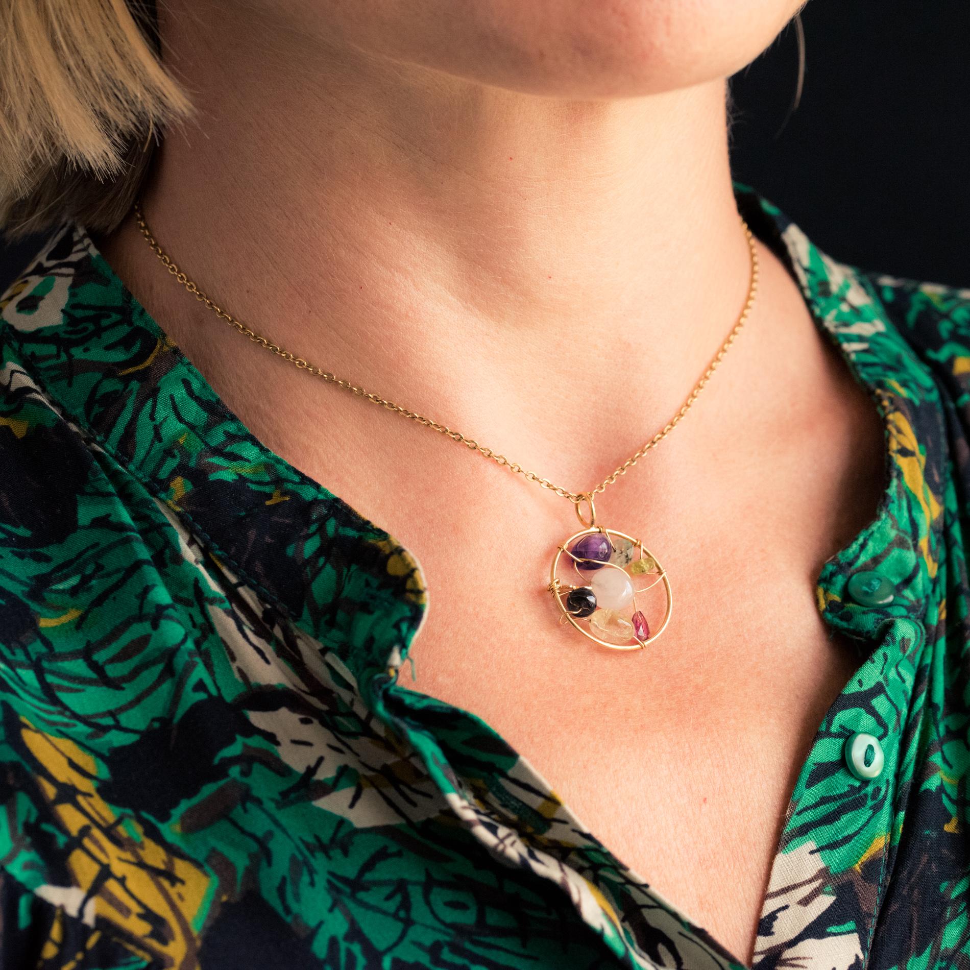 Pendant in 18 karat yellow gold.
Round shaped, this second-hand pendant from the Tous brand is formed by a gold circle within which several gemstones, whether or not cut, are fixed by gold threads running through them. A small bear symbol of the