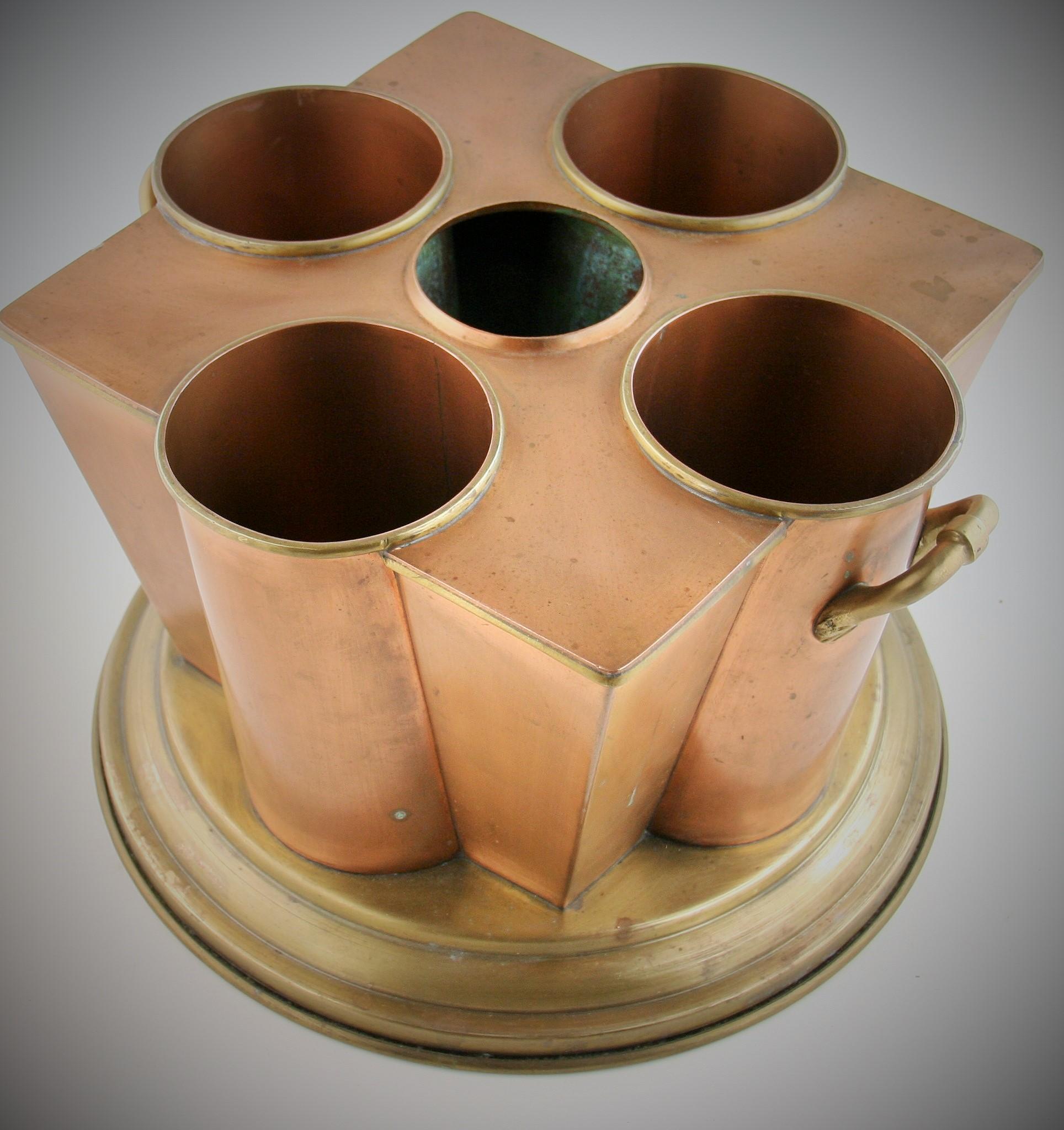 8-260 Modern geometric brass and copper center piece/flower holder with brass handles.
Top part is copper bottom is brass.
Can be used as wine cooler by placing ice in center compartment which will cool surrounding bottles
 