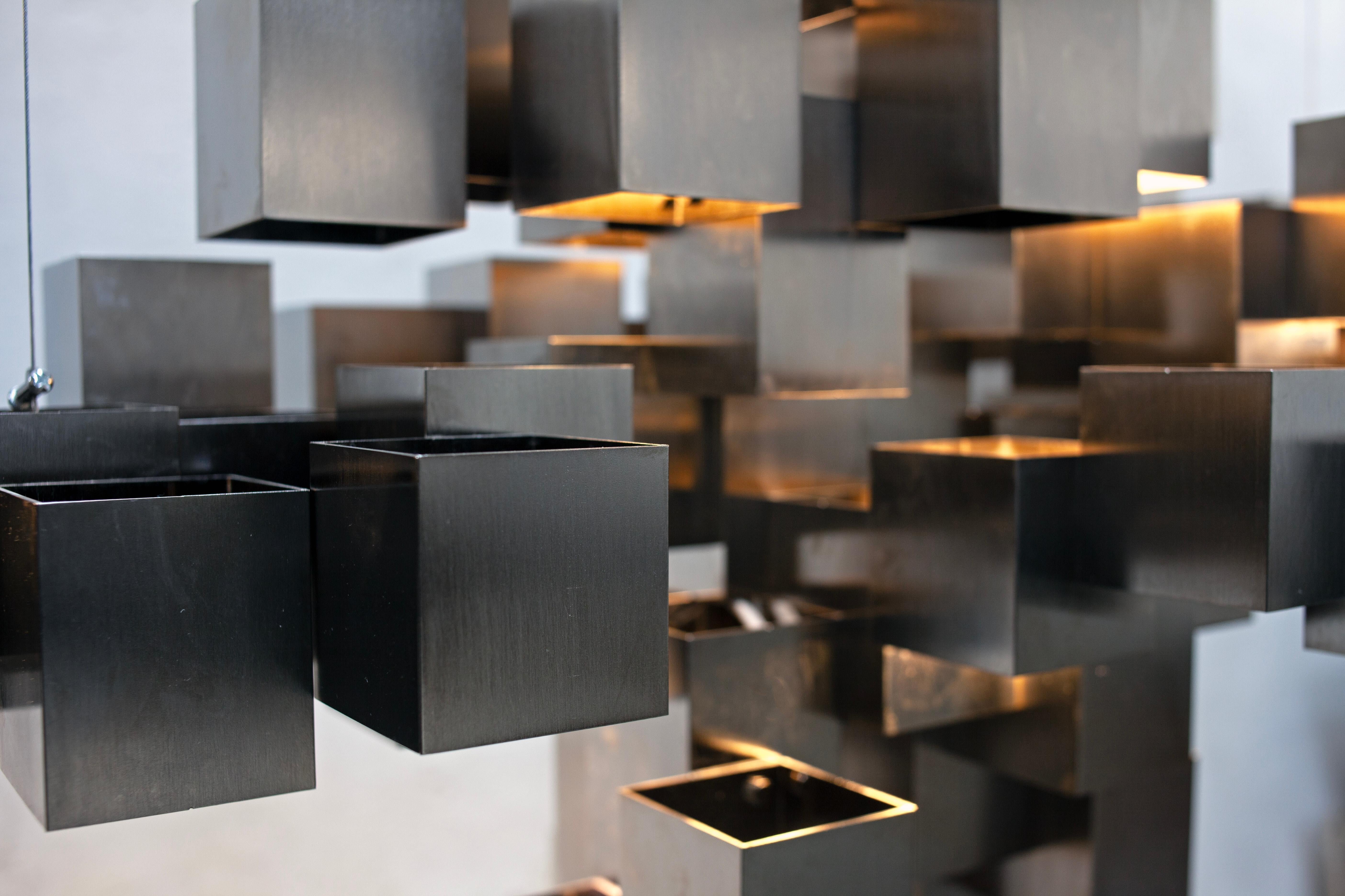 Disegnata originariamente da HP Sommer, la collezione di lampadari Brass Cubes si ispira alla forma della nuvola e viene trasformata in una sorta di pixel. La nuova versione nichelata 174 è dotata di 29 lampadine a led G4 che creano un effetto