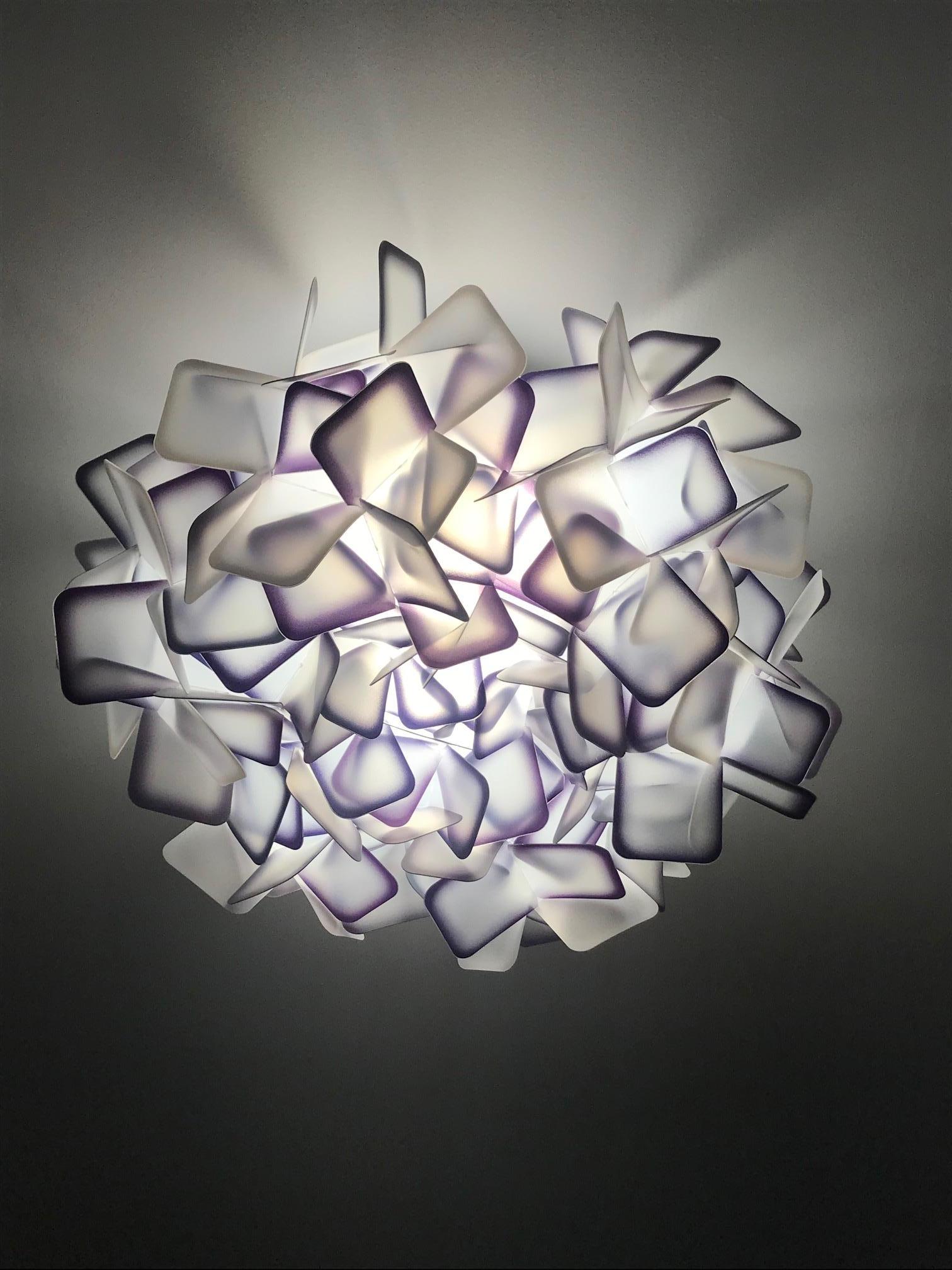 Exquisite ceiling light or wall sconce comprised of multifaceted interlocking resin squares. The square clusters are made of the patented Opalflex developed through the recycling of technopolymers and glass crystals. The resin squares are frosted