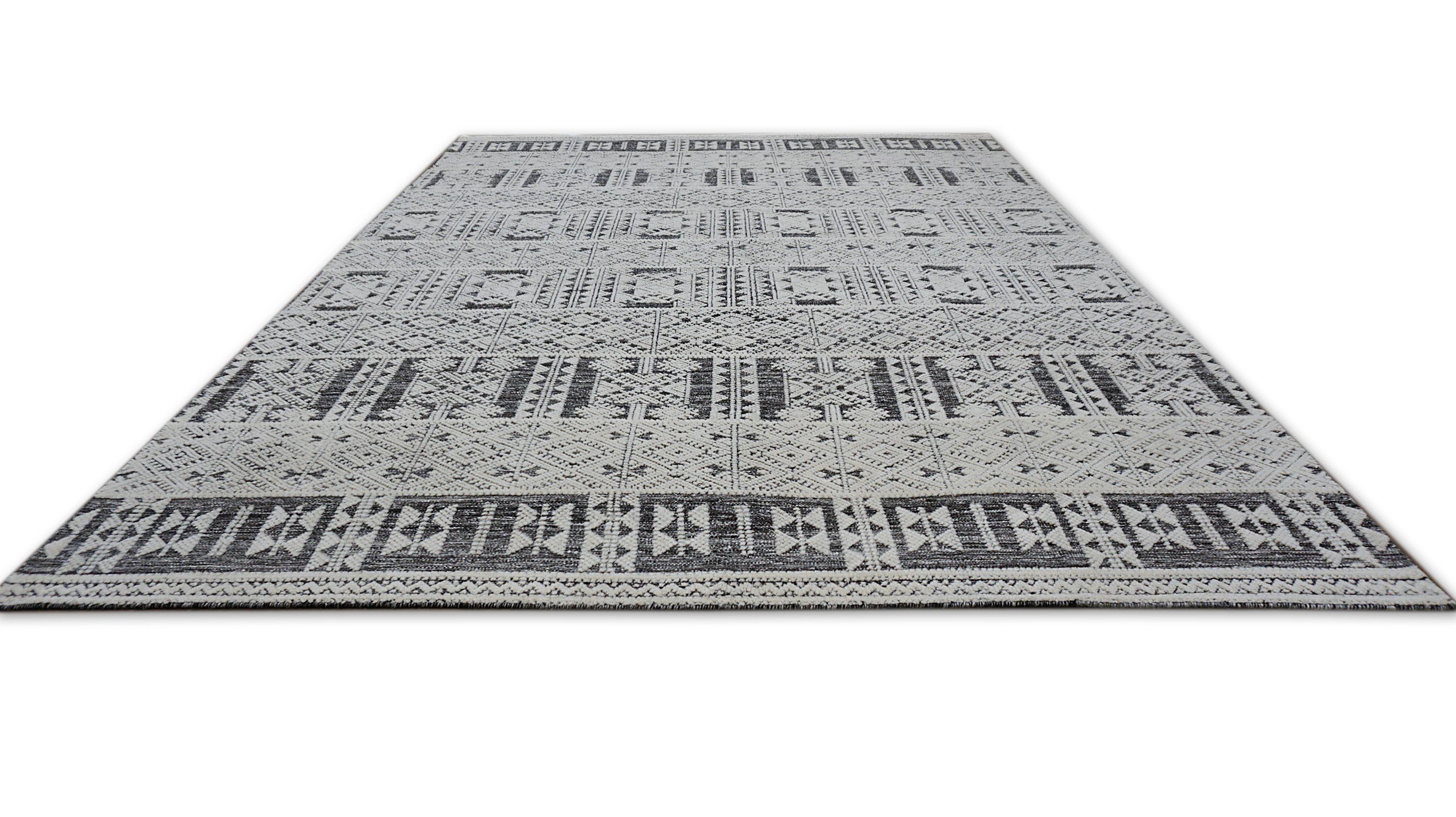 Esta alfombra de lana anudada a mano es un cautivador ejemplo de arte tribal moderno, inspirado en antiguos motivos geométricos. Elaborada con meticulosa atención al detalle, esta alfombra presenta una sorprendente combinación de intrincados