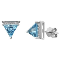 Clous d'oreilles modernes géométriques en or blanc précieux avec diamants et topaze bleue