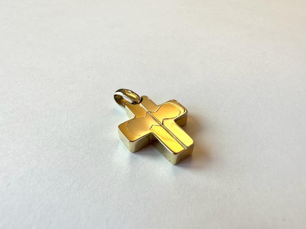 This 18kt gold pendant has a very modern twist by interweaving yellow and white gold. This beautiful german cross has a bright-finish. A bright finish is any metal that has been polished to a mirror-like finish. The cross is in very good used