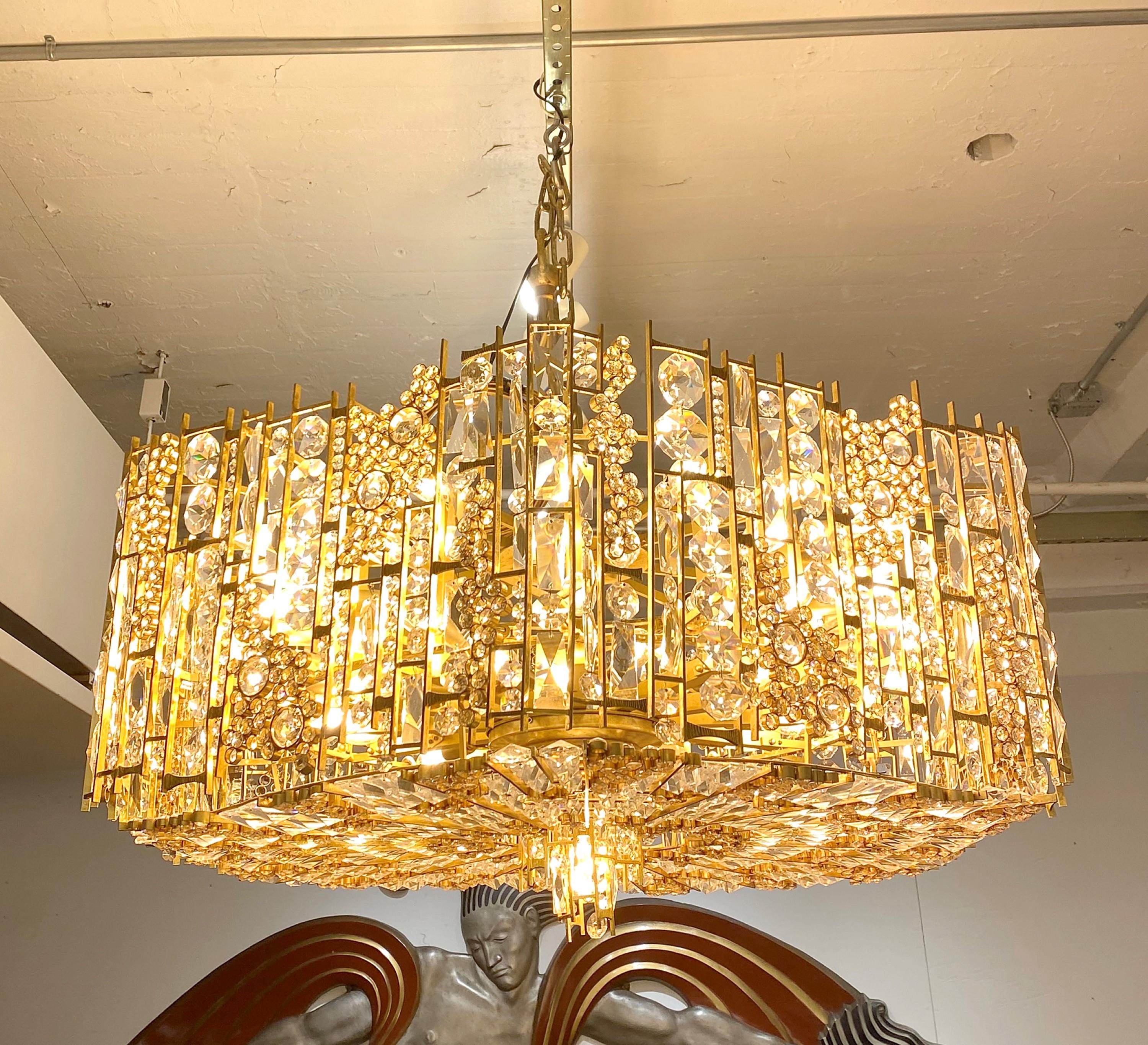 1960s German made Modern style gilt brass crystal chandelier manufactured by Palwa Lighting. Each lighting fixture was made by hand and consists of hundreds of individual gilded brass parts with different size and shape crystals inserted in each.