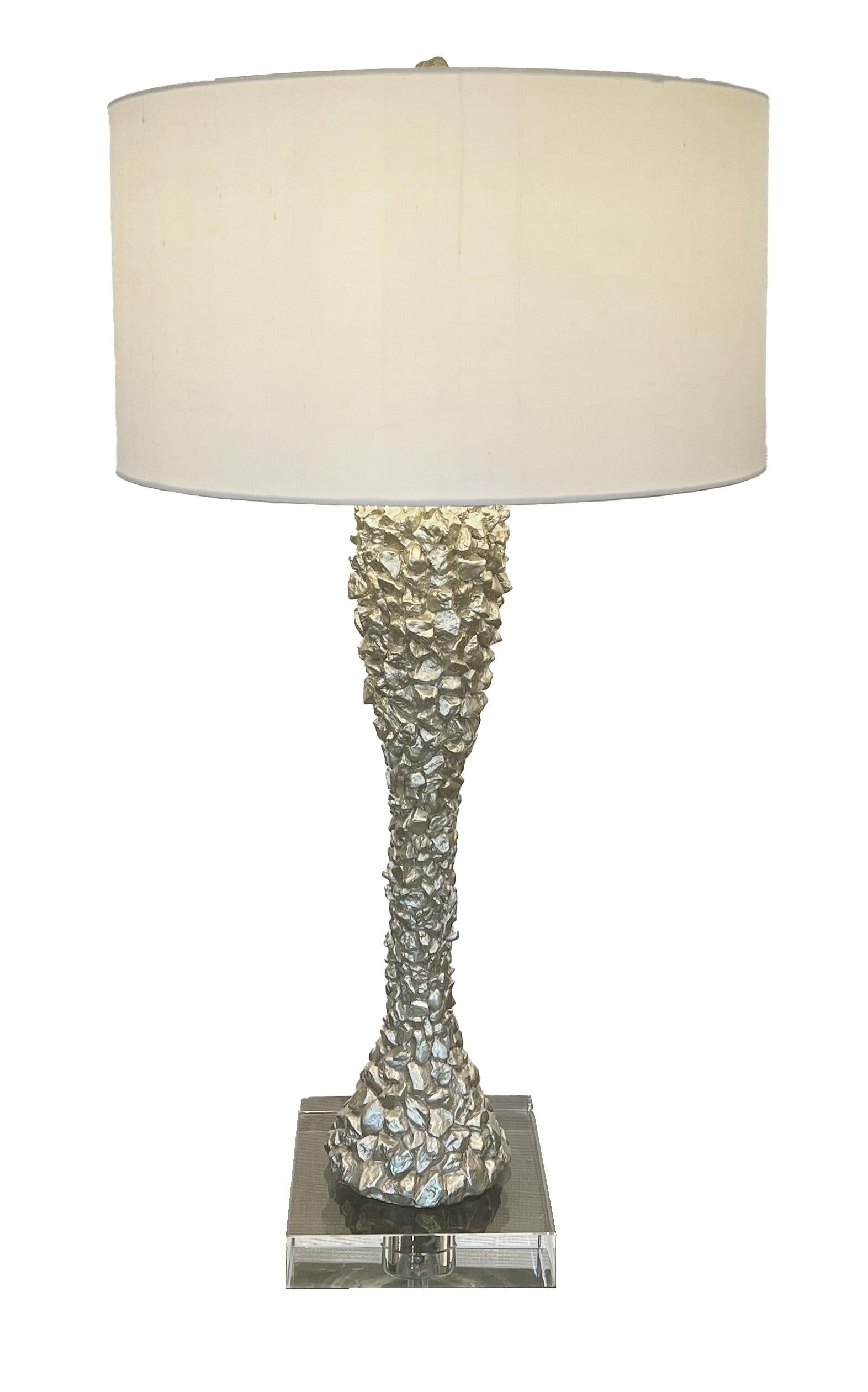 Modern glamour lamp with clear acrylic base & ivory silk shade. The textured base is a beautiful shade of champagne. It flows seamless with other brass or chrome accents.