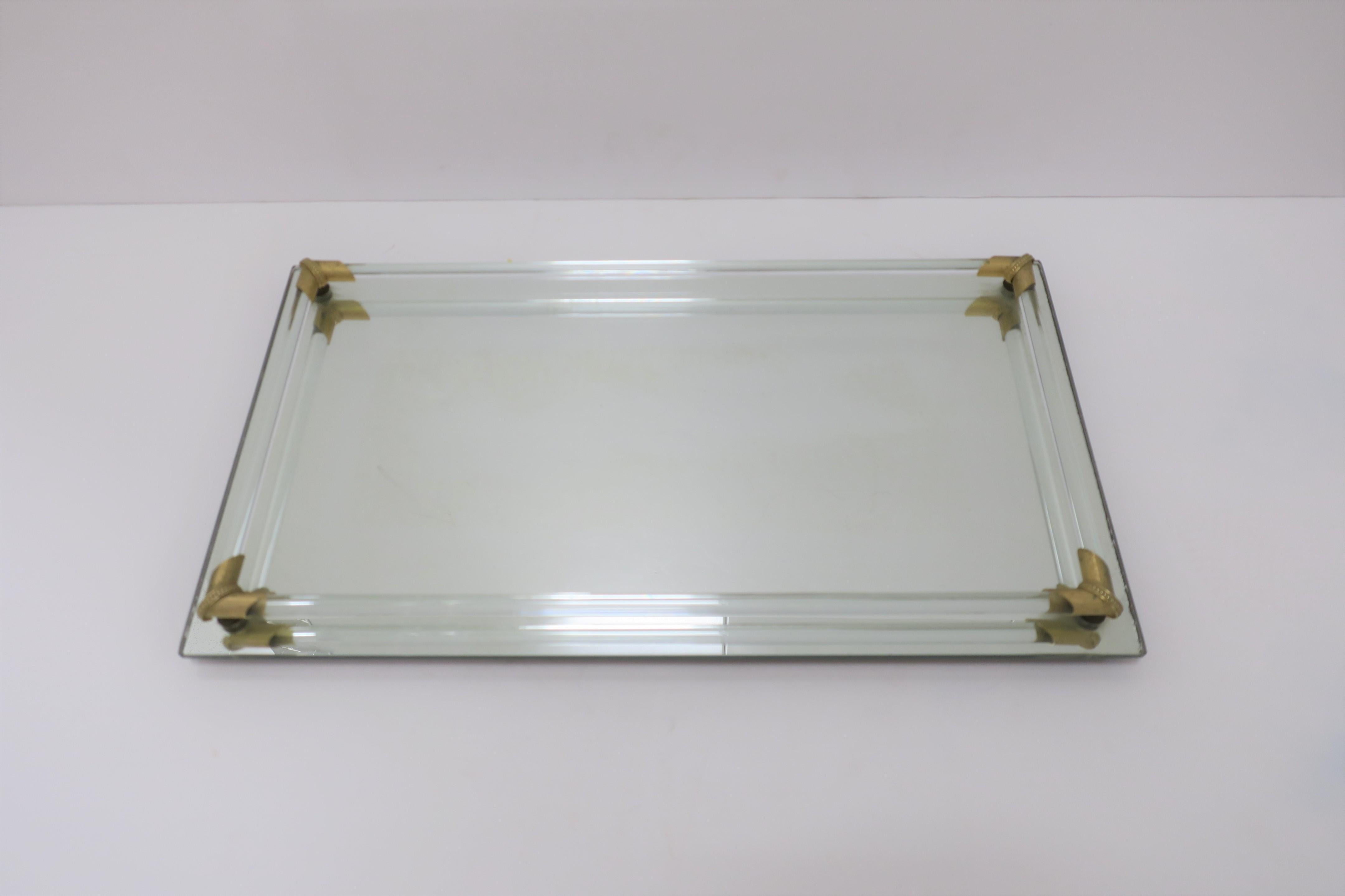 A 1970 modern rectangular vanity tray, with glass rods and brass decorative corner detail, on a mirrored base tray.