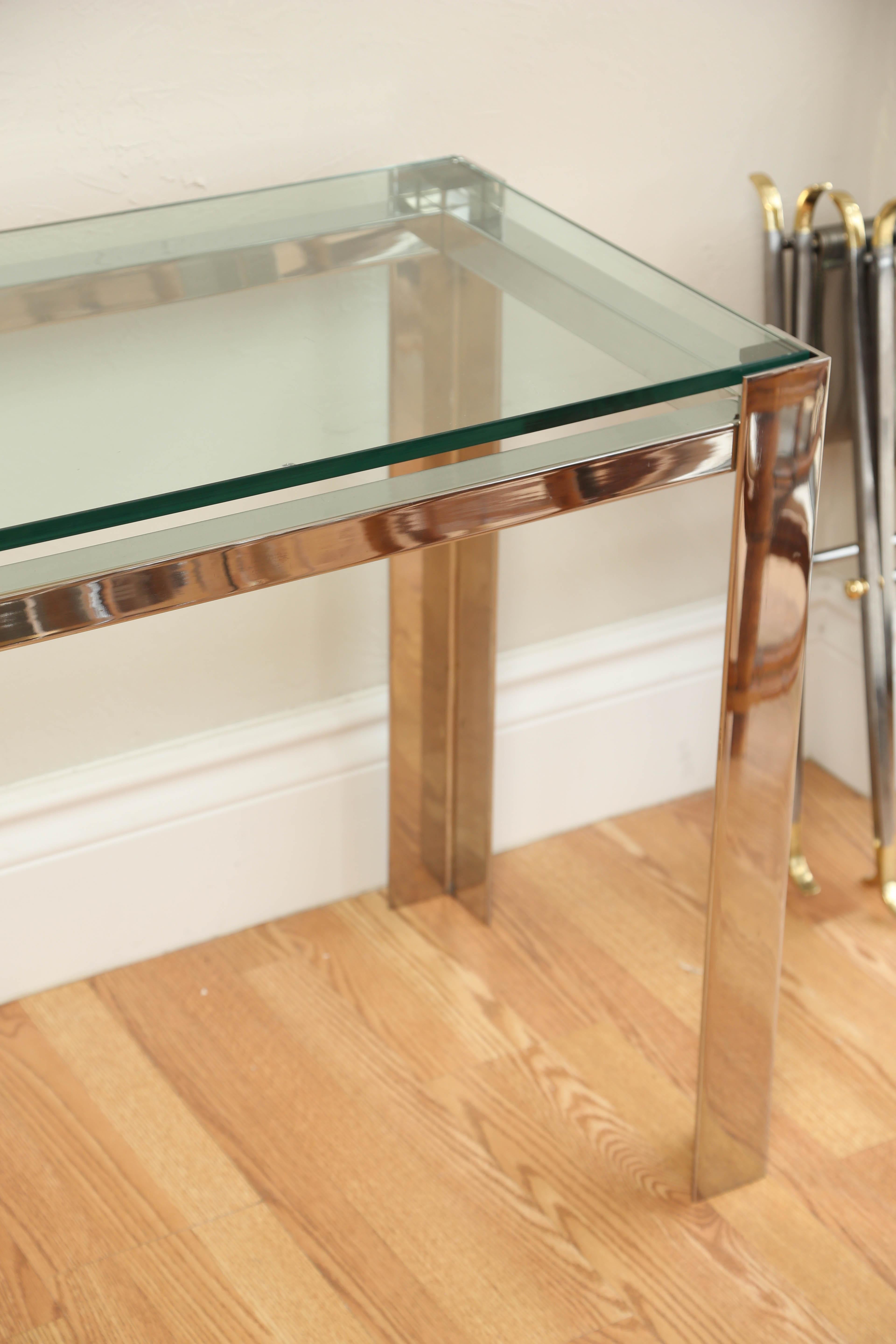 Striking chrome console with inset glass top.