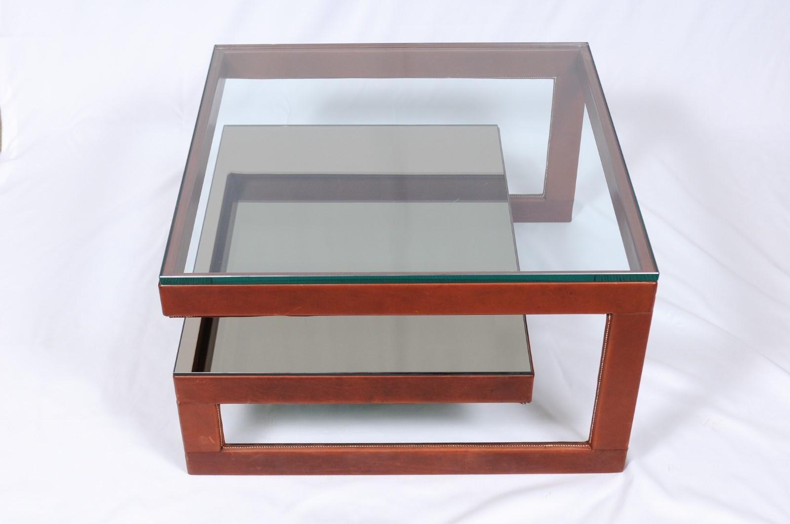 Architectural and sculptural, this coffee table is both simple and layered. Glass and leather wrap in clean lines for a contemporary statement.