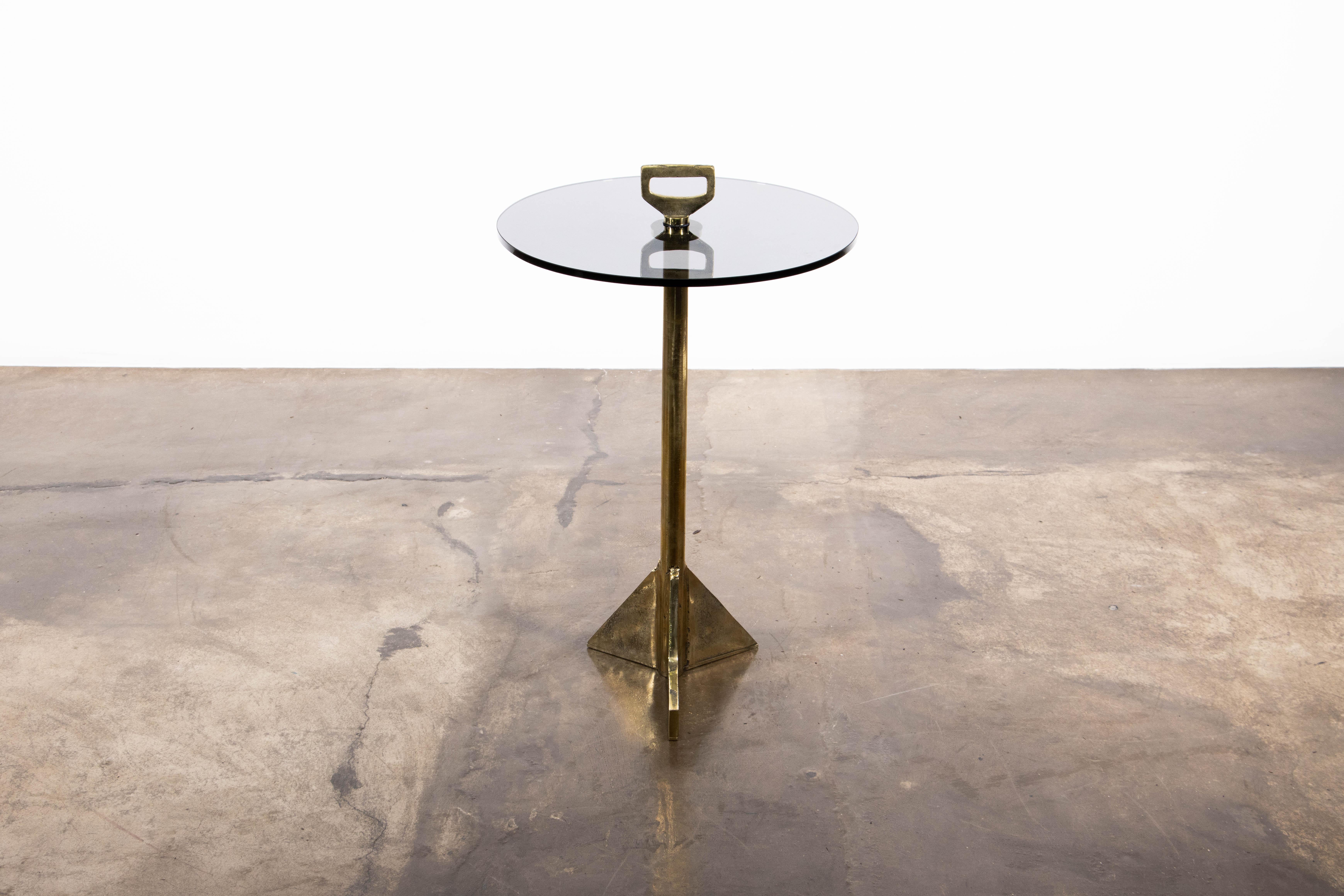This playful table made of cast bronze and smoked glass features asymmetrical 
