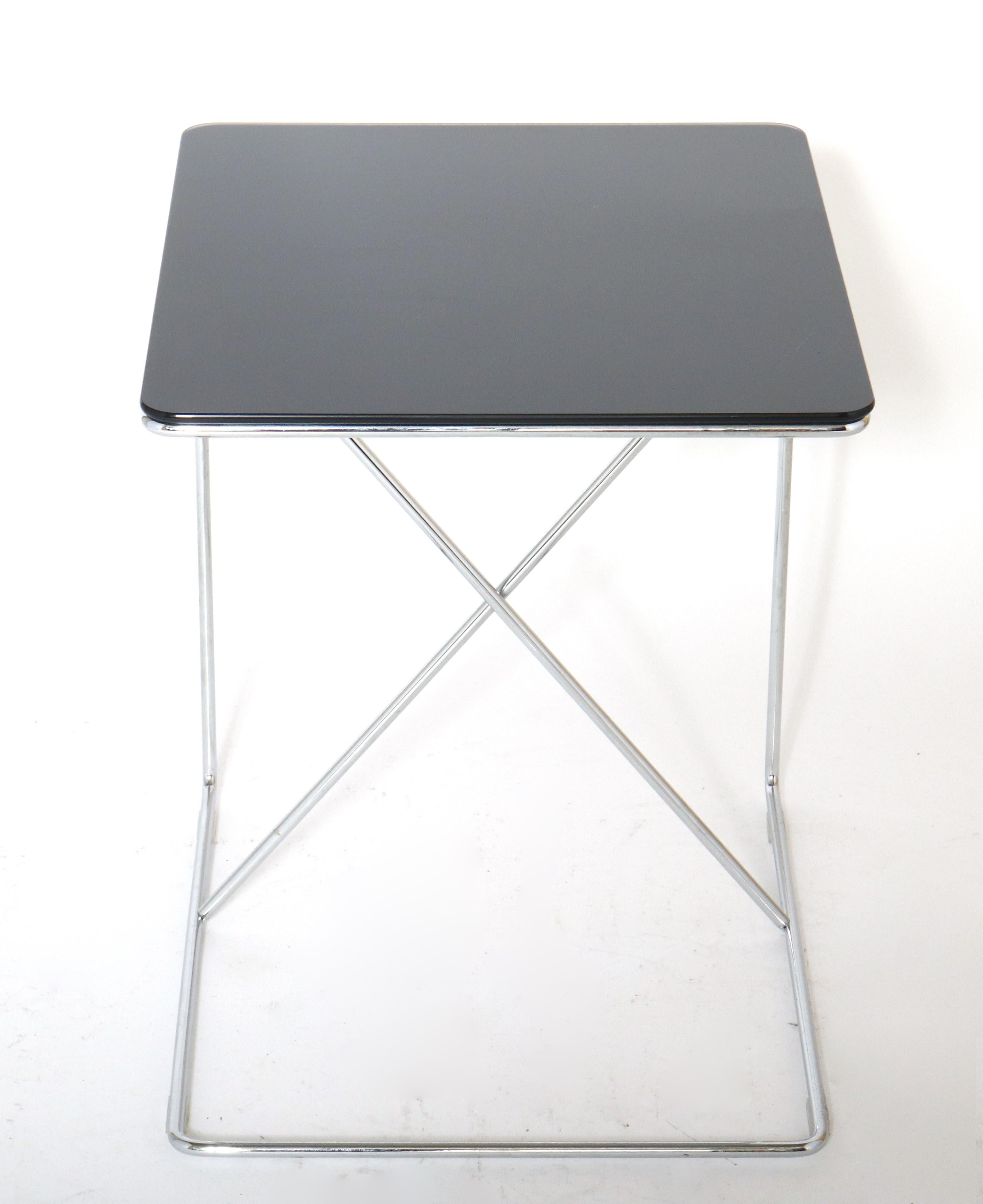 Modern glass and metal side C-table. The piece has a black glass top and a chromed metal base. In great vintage condition with age-appropriate wear and use.