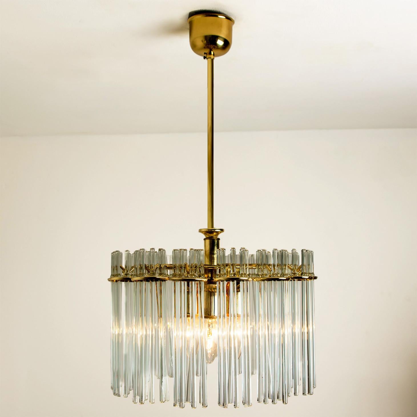 Clean lines to complement all decors. Wonderful high-end light fixture by Sciolari for Lightolier. With brass detail hanging glass giving the piece an elegant appearance which refracts the light, filling a room with a soft, warm glow

The chandelier