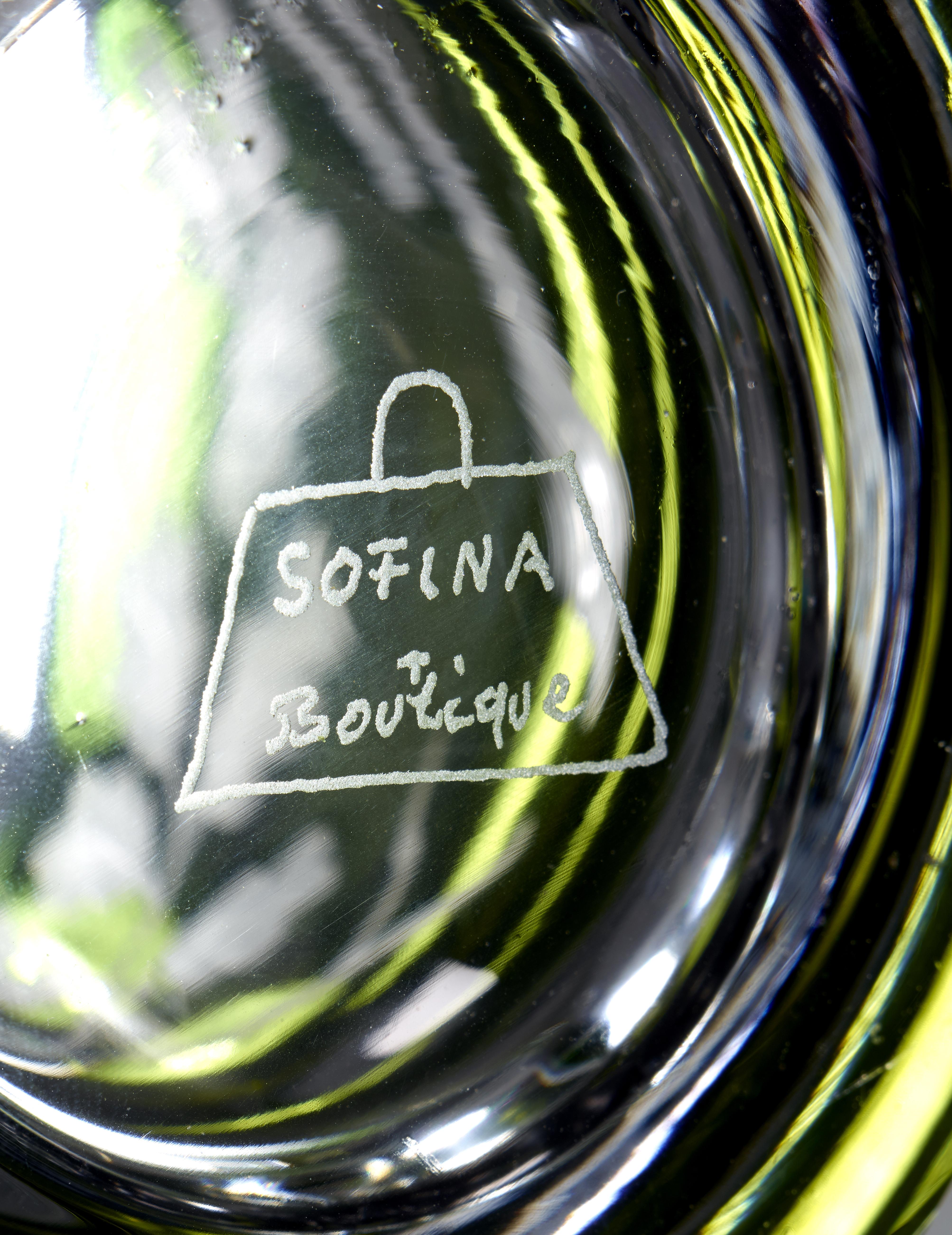 Vase aus mundgeblasenem, modernem Kristall mit zwei auf Eichenblättern sitzenden Vögeln in grauem Glas.
Das Dekor wird freihändig von Glaskünstlern rundum von Künstlern in Bayern von Sofina graviert.
Sofina Glas und Porzellan wurde 2013 in Bayern