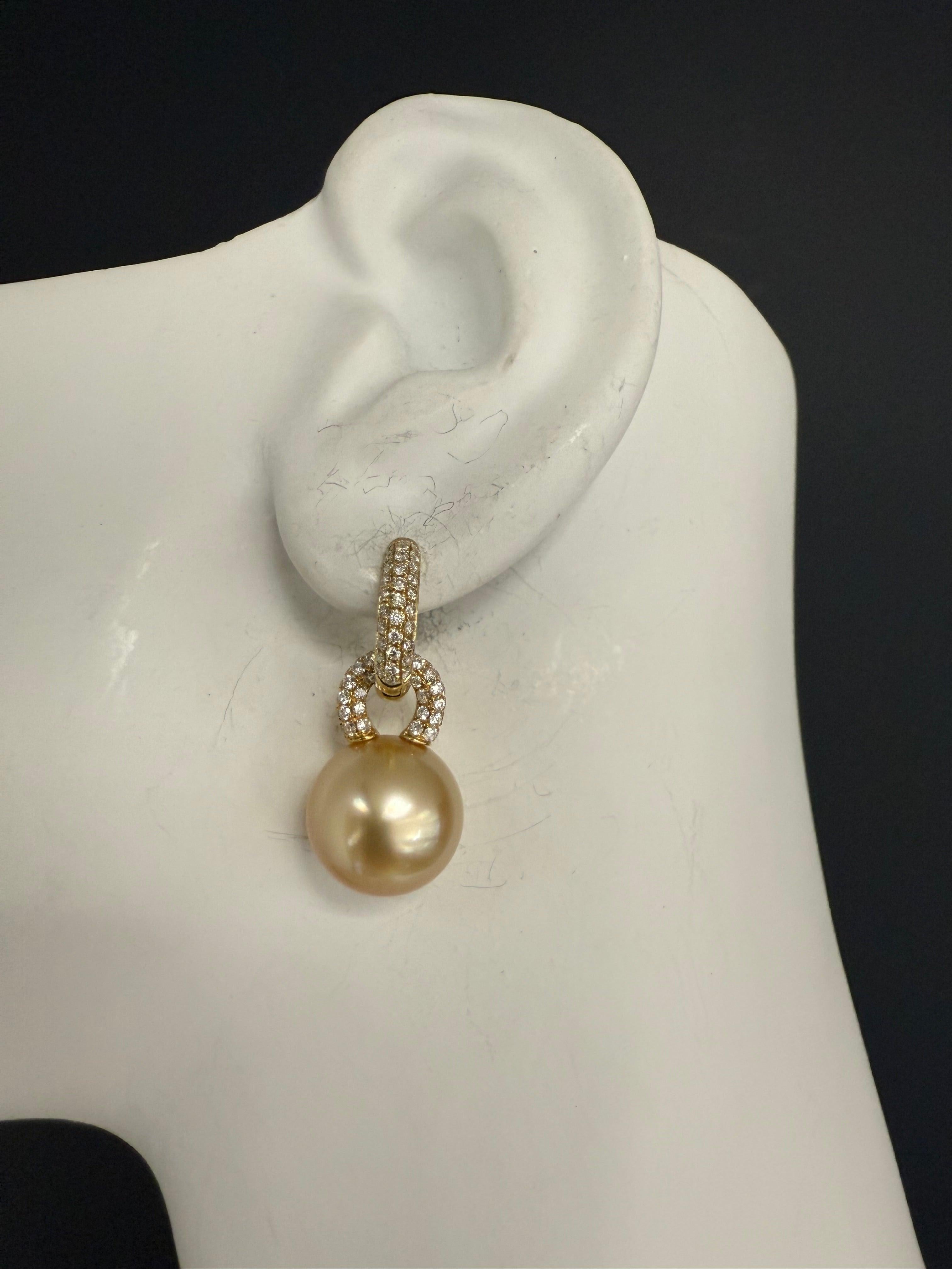 Impresionantes pendientes modernos con perlas cultivadas de los Mares del Sur de color champán de 12 mm engastadas en oro amarillo de 18 quilates. Las perlas son de calidad excepcional, con nácar grueso y gran brillo. El diseño está adornado con un