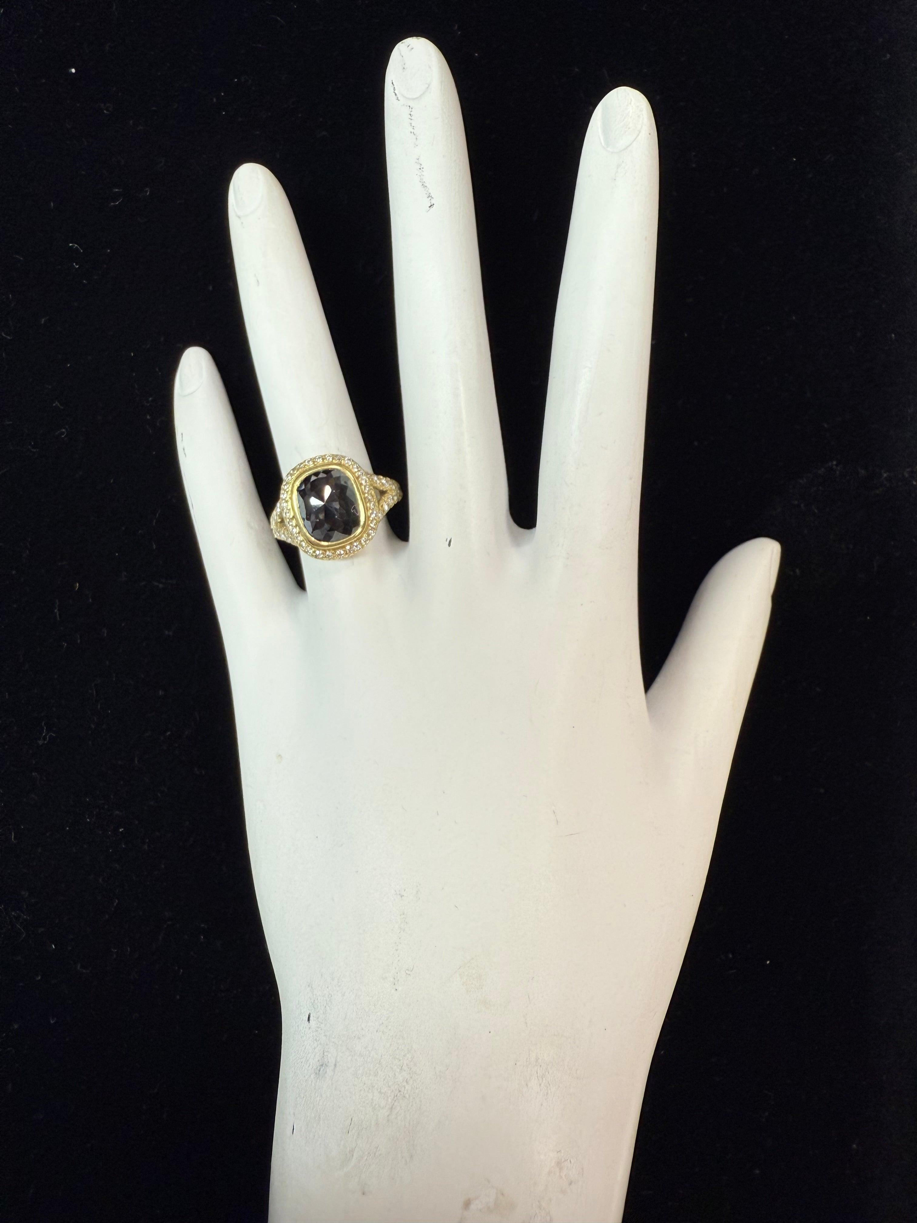 Cette �élégante bague est ornée d'un diamant noir naturel de taille rose (environ 9,5 x 7,5 mm) serti sur un chaton en or jaune 18 carats massif. D'un poids de 8,6 grammes et d'une taille de 5,25, elle présente une tige fendue sertie de 44 diamants