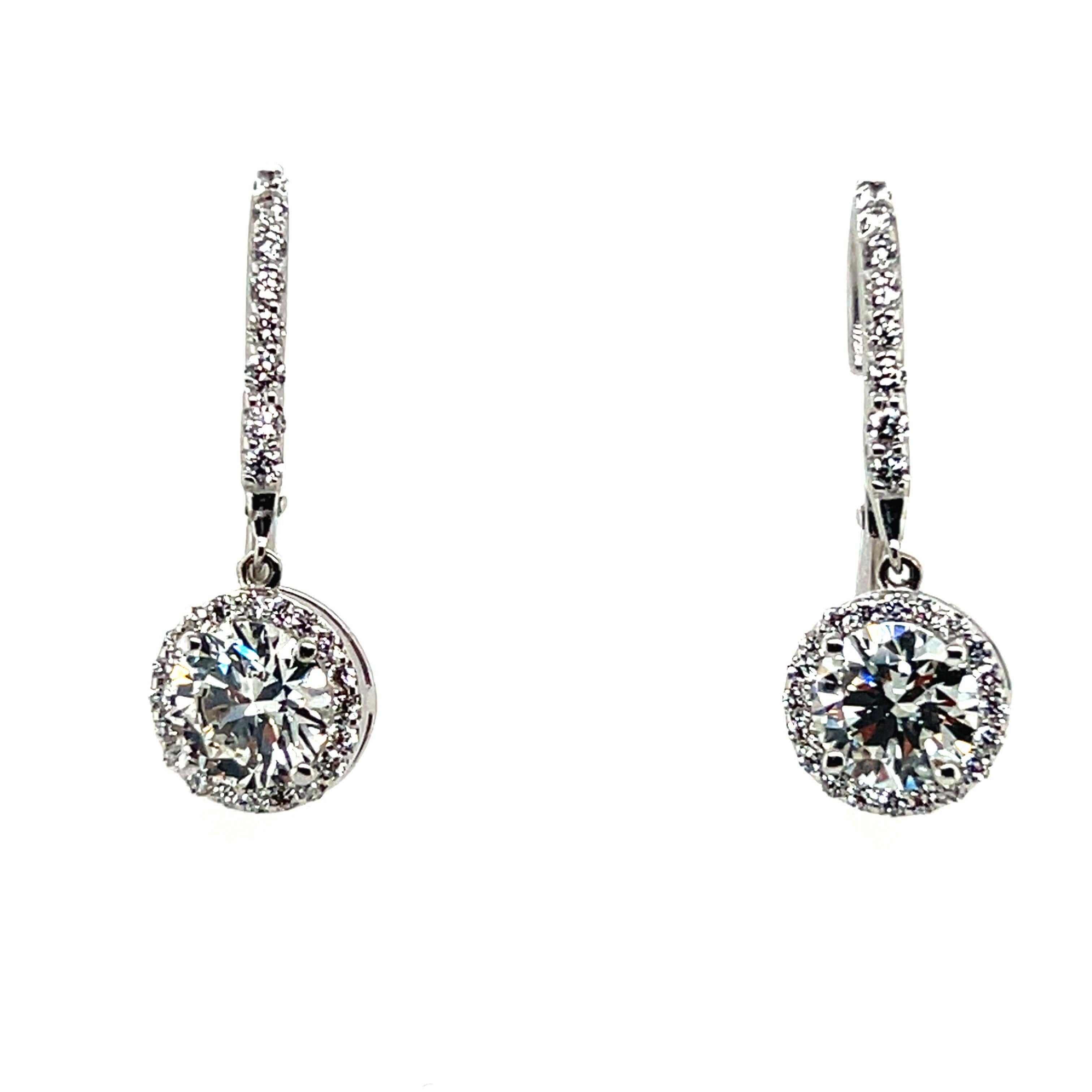 A stunning 14k White gold matching pair of egl usa certified f color, si2 clarity 2.01 carat set of natural round brilliant ideal cut diamonds. The mounting includes 56 natural colorless rounds weighing approximately 0.69 carats. 

The first is a