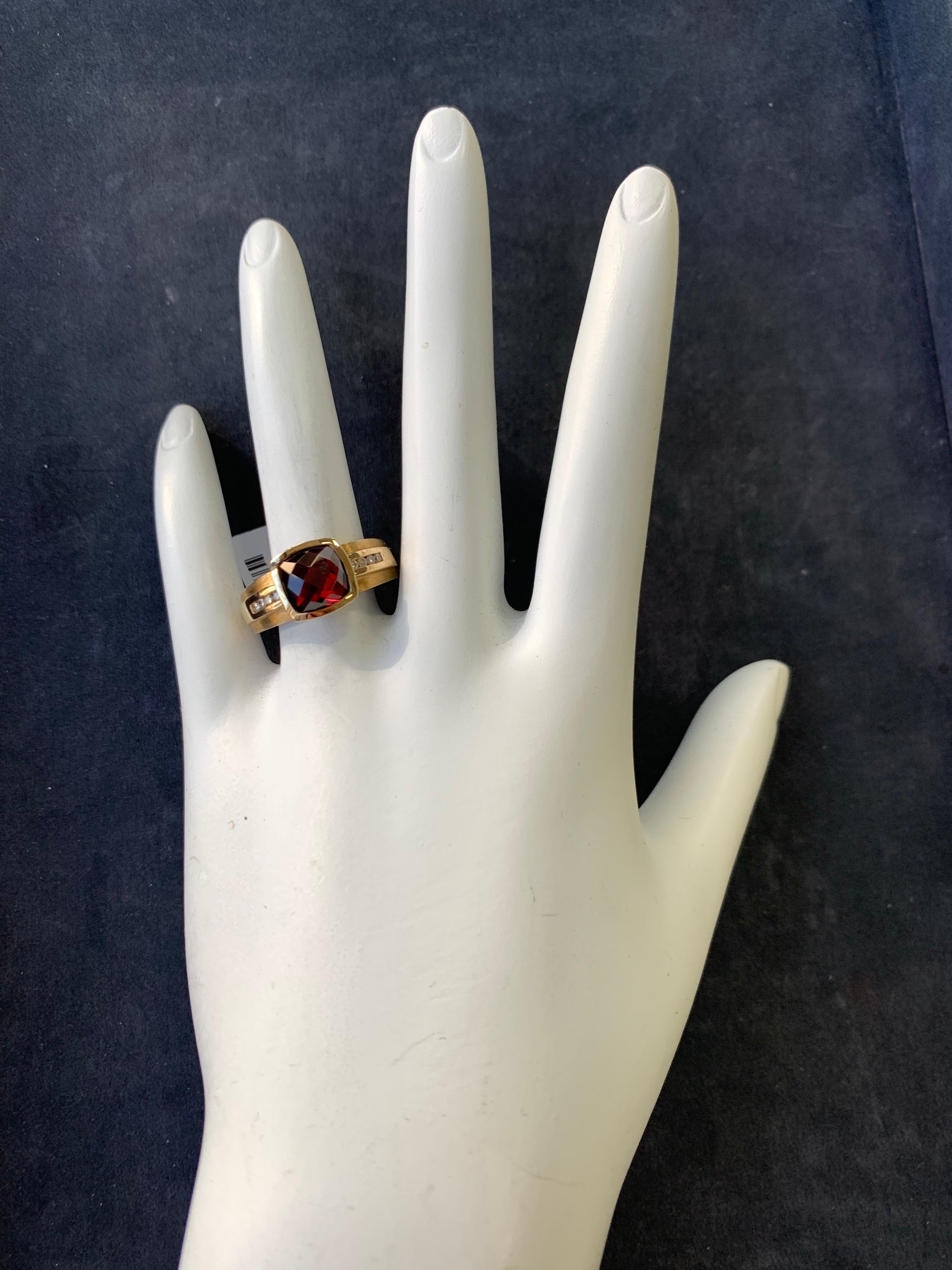 A stunning 14k yellow gold ring. The natural garnet weighs 3.41 carat and measures approx 7.5x8.2mm and is cut with a checkerboard pattern. Included are 8 natural round brilliant diamonds weighing 0.14 carats and the ring is a size 6.25. Total