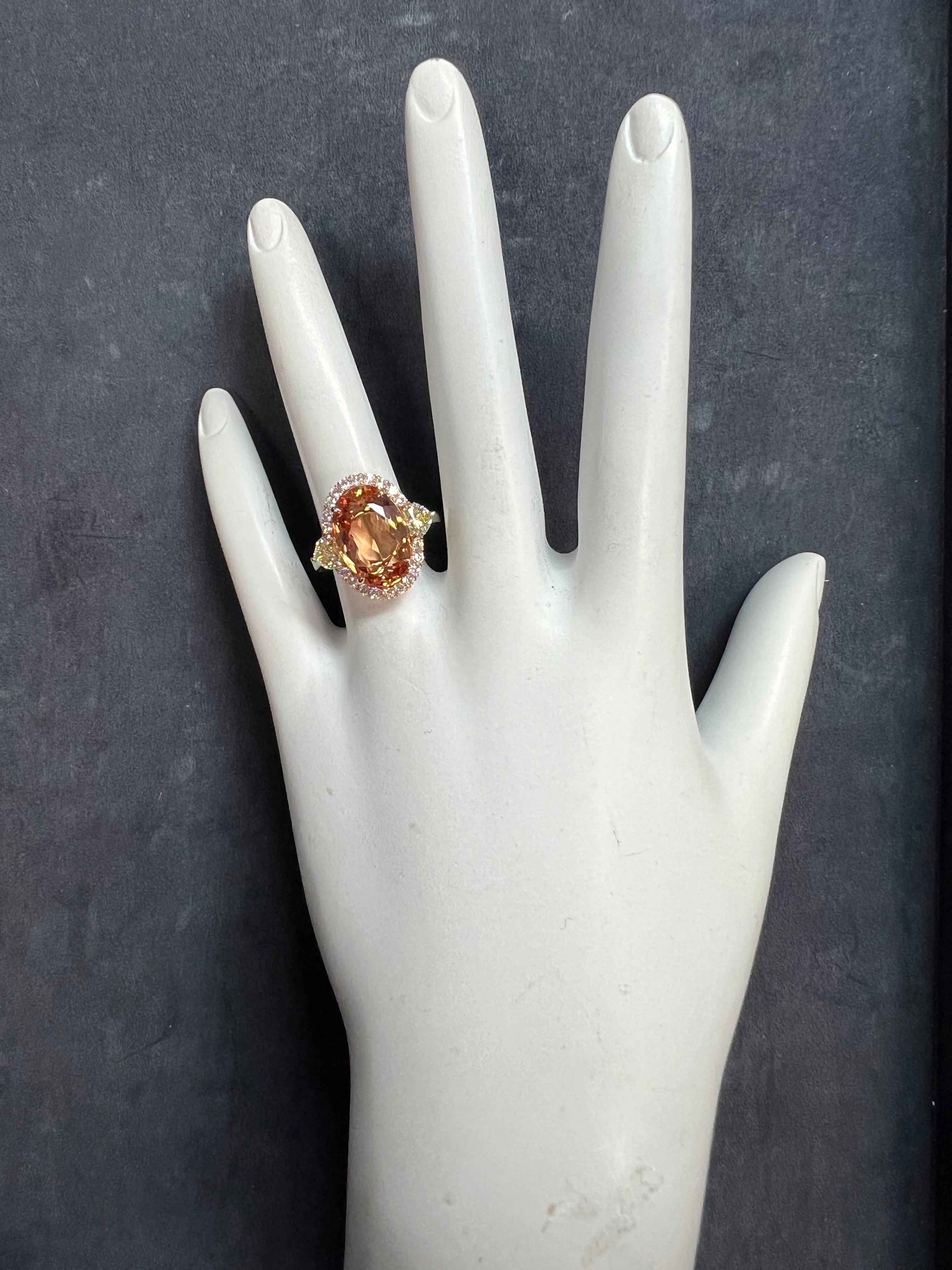 A magnificent 18k Rose and White Gold Natural Imperial Topaz and Diamond Ring. 

The center stone is a rare peach color natural Imperial Topaz 5.97 carat measuring 13.96x9.44x5.28mm. The center stone is flanked with a matching pair of GIA certified